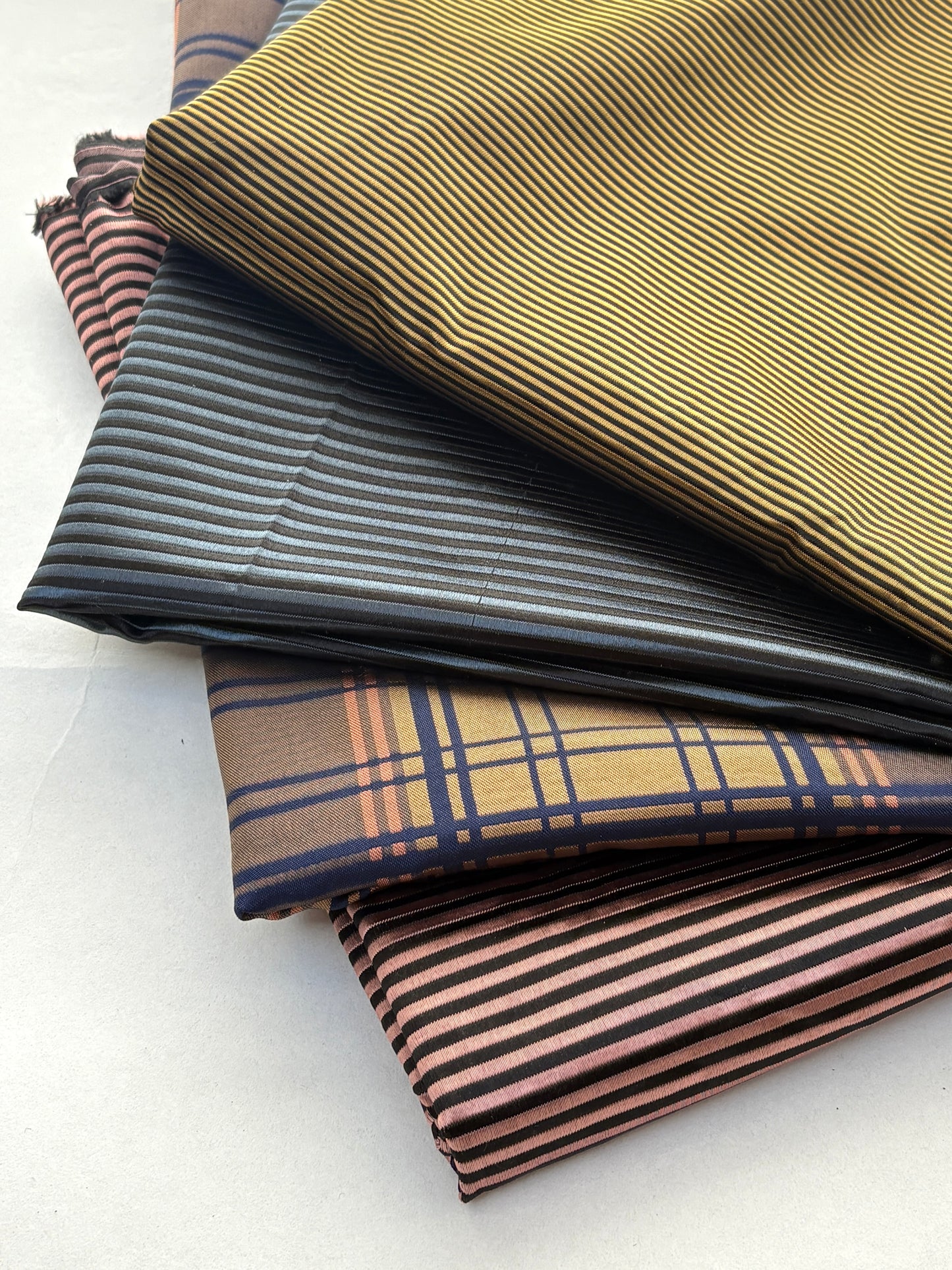 Collection of fabric swatches in various patterns and colors on a white background