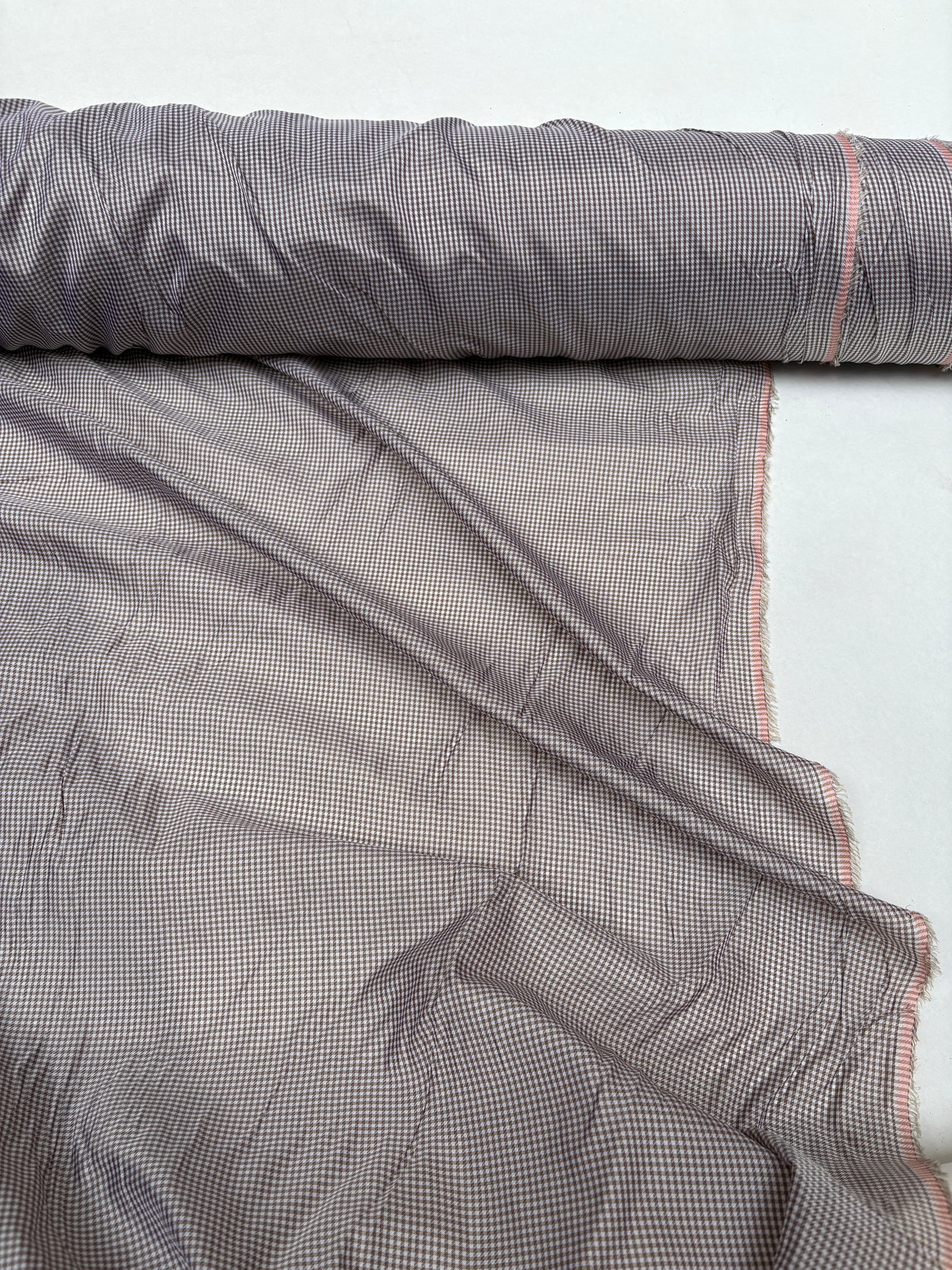 Rolled check fabric is displayed with soft wrinkles on white