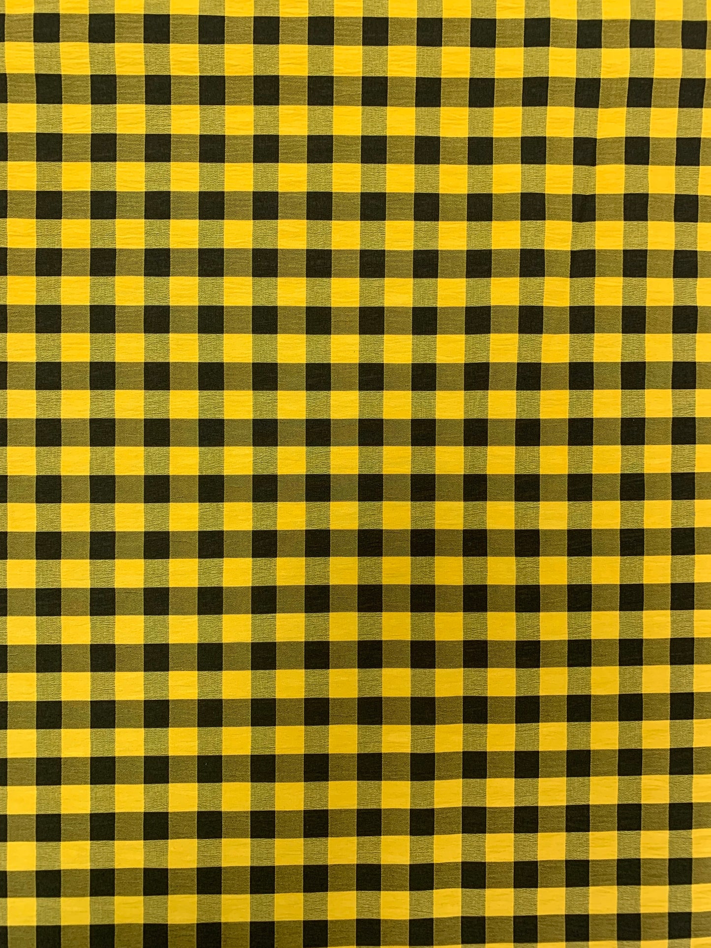 Black and yellow gingham fabric is shown in close-up