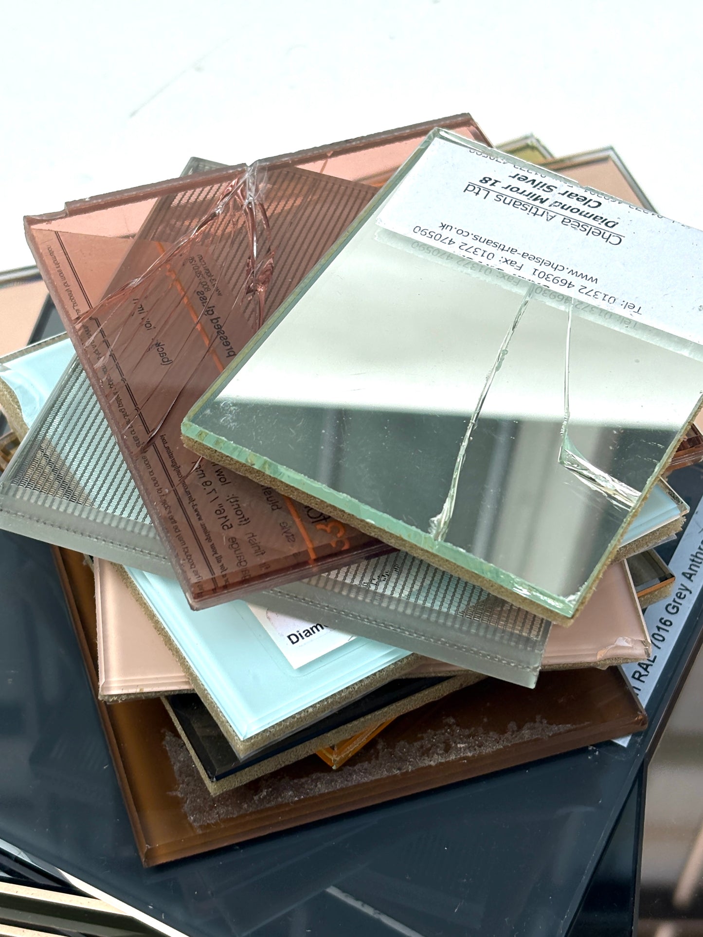 Layered glass and mirror offcuts against a white background