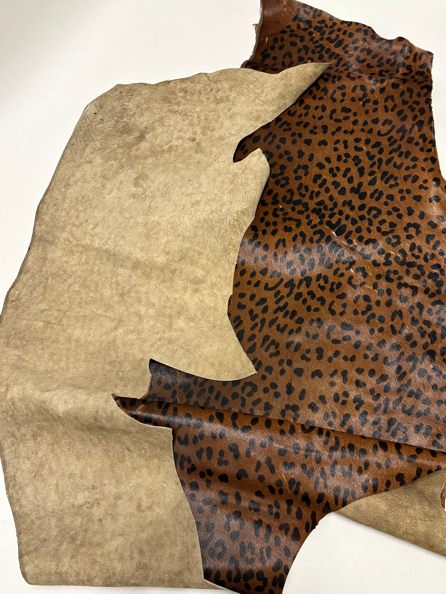Leopard print fabric partially folded on a white background