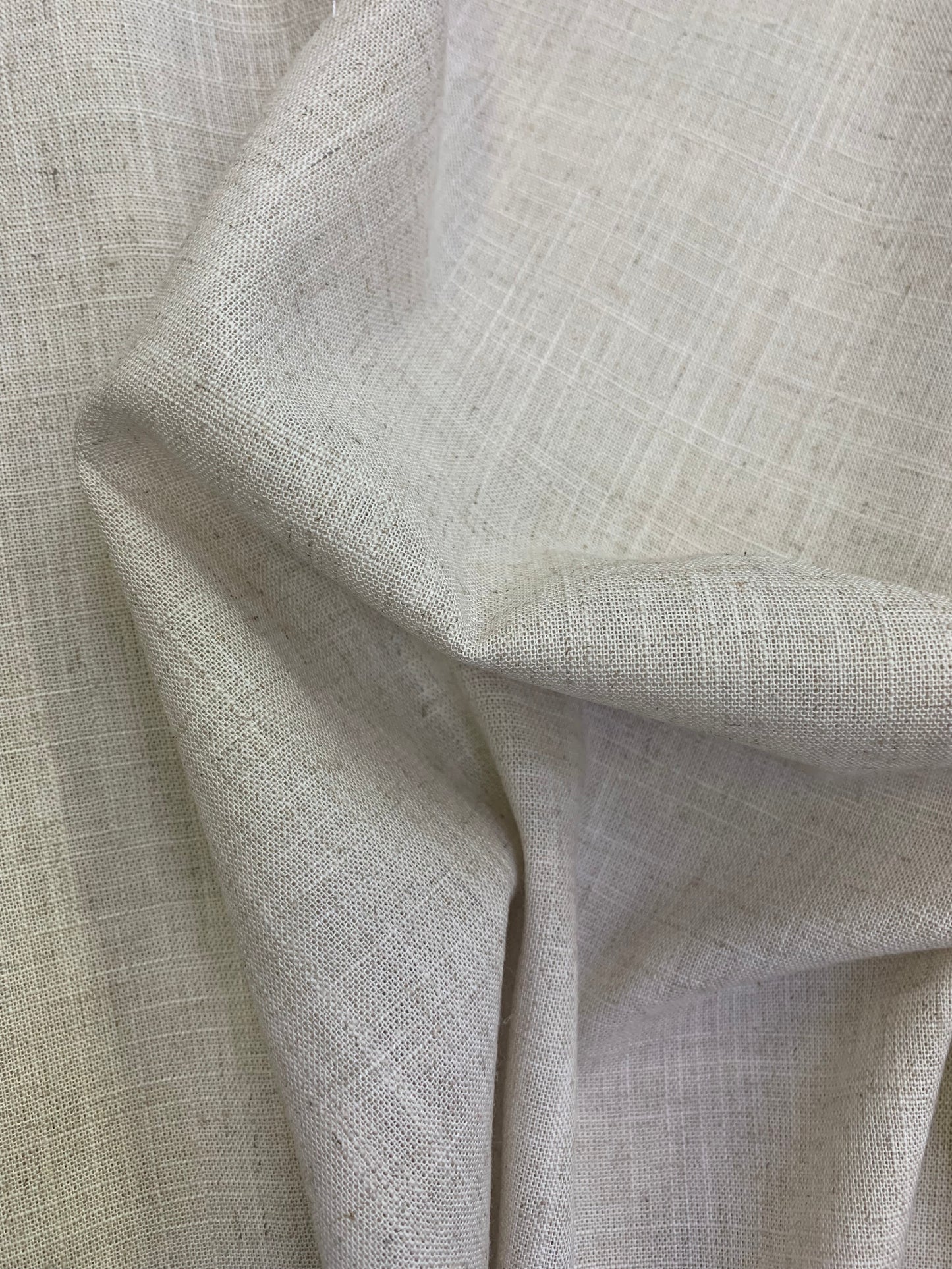 A close-up detail of natural coloured viscose linen deadstock fabric with subtle texture.