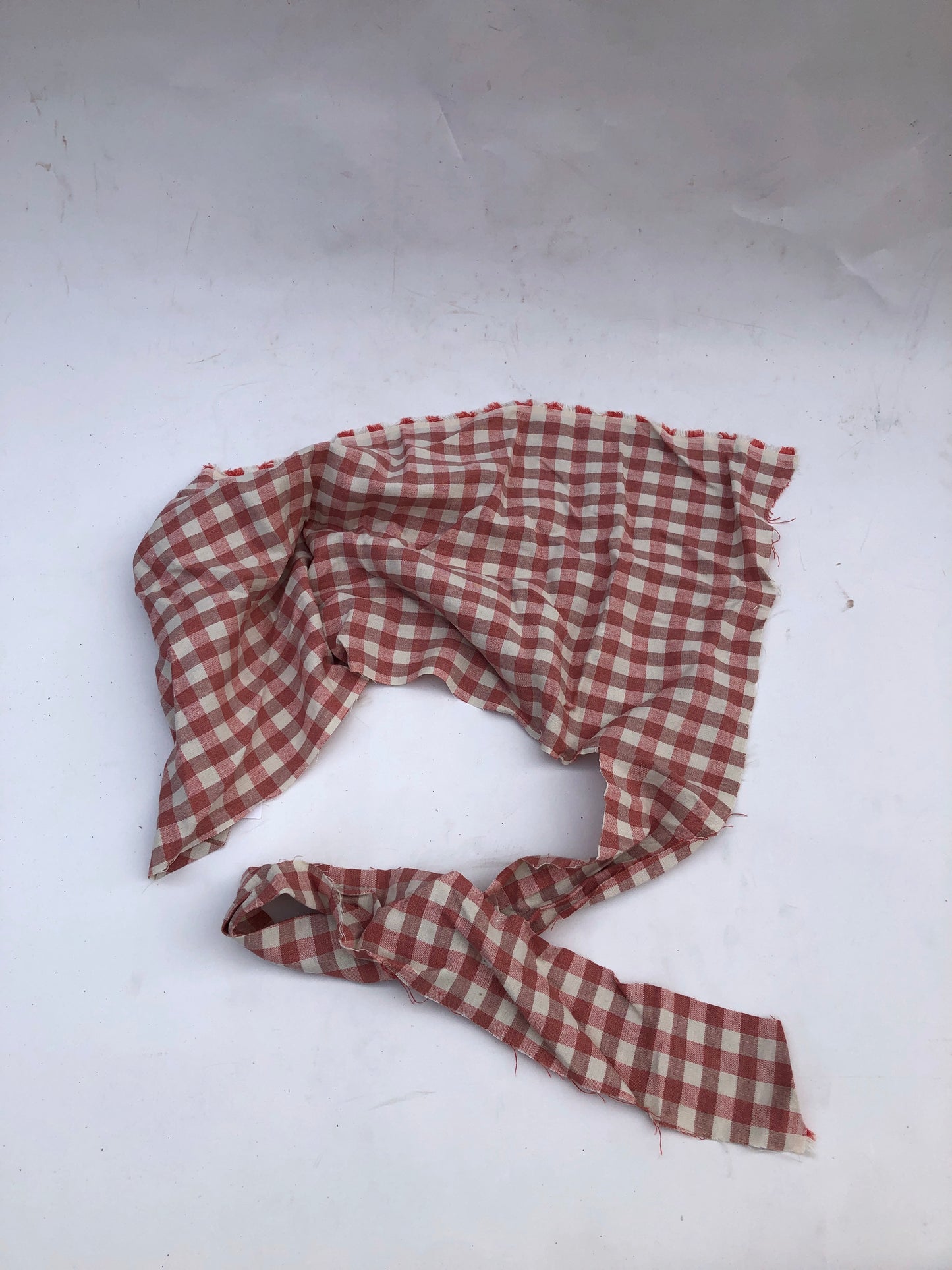 A checked fabric piece is laid flat on a white background.