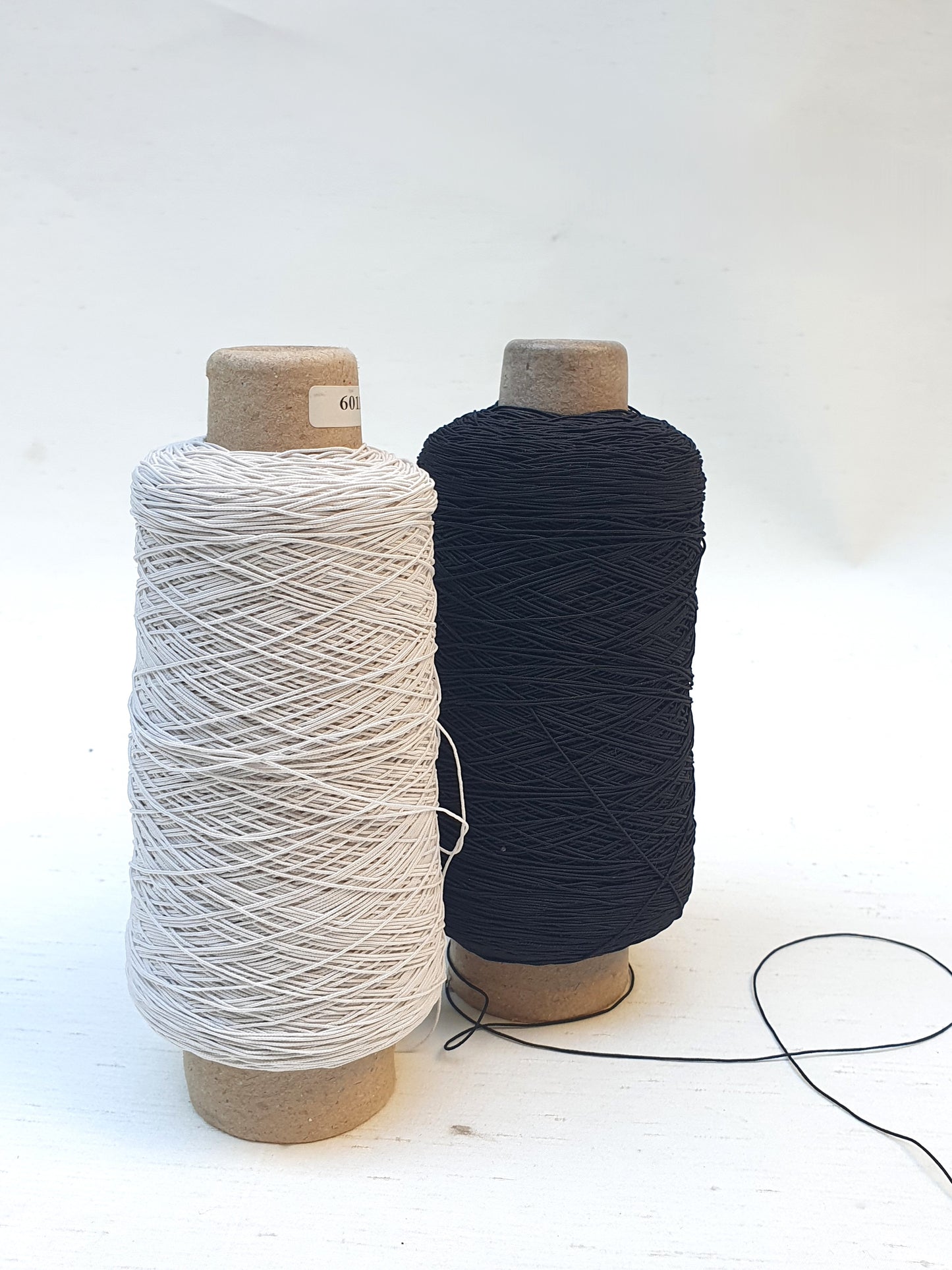 Two elastic cord rolls in black and white