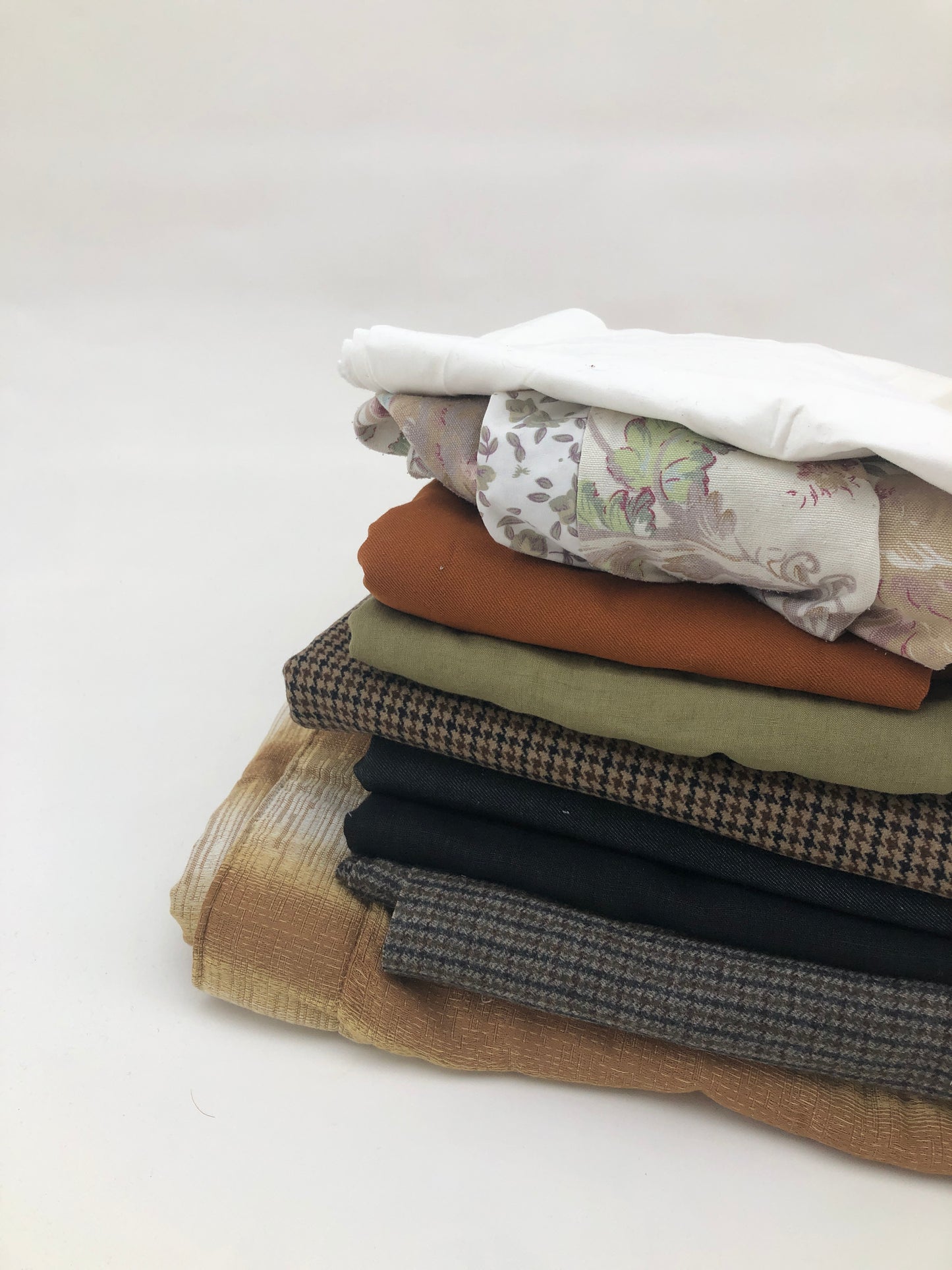 Stack of large pieces of earthy-coloured fabrics