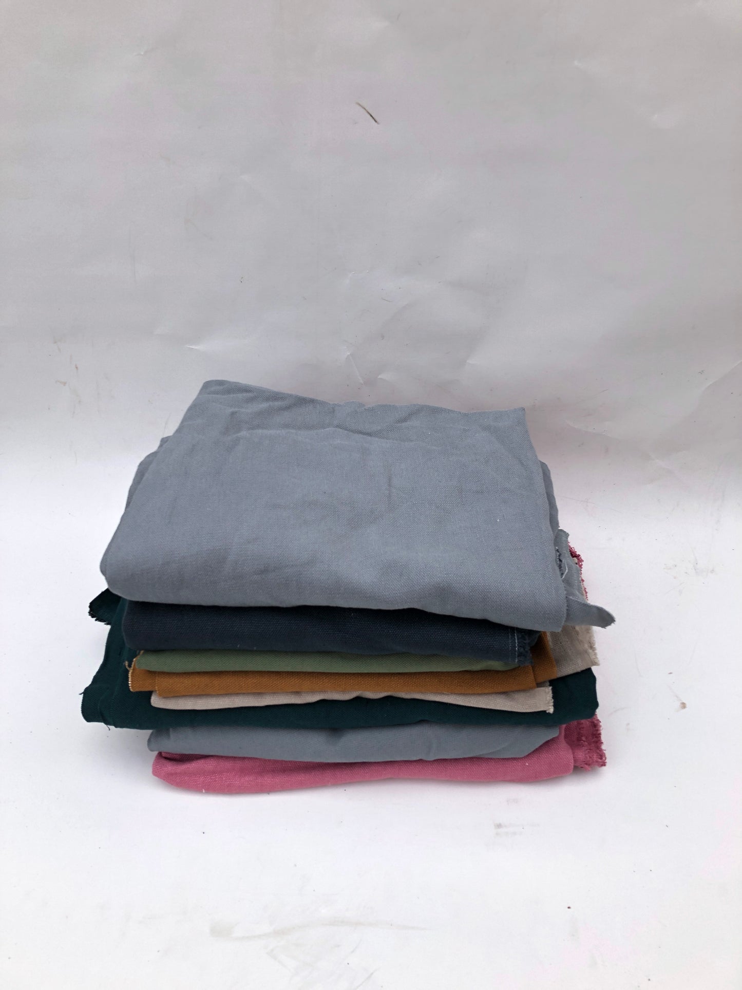 Stack of heavyweight linen fabric in various colours