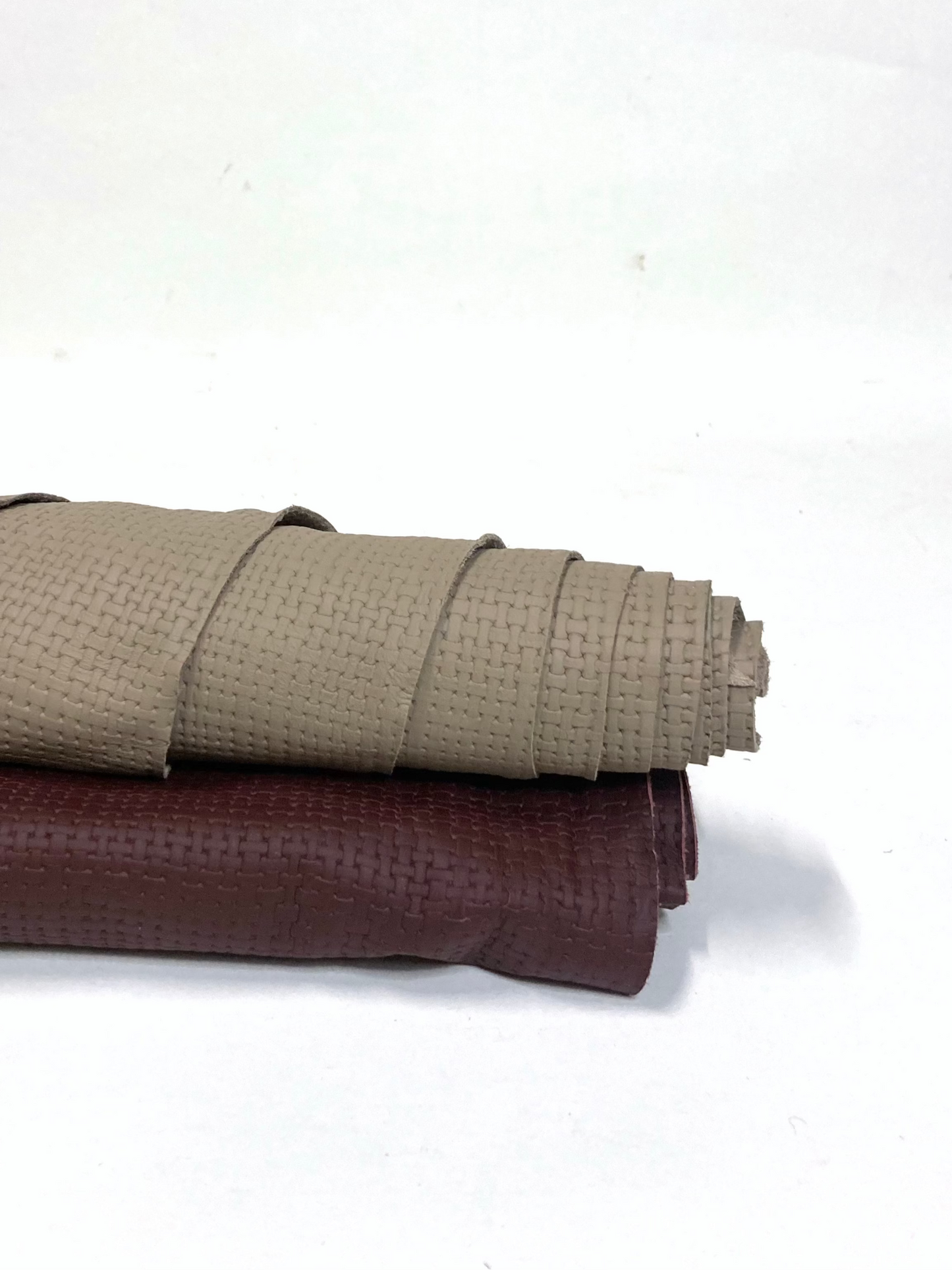 Two rolled-up embossed leather, one beige and one brown