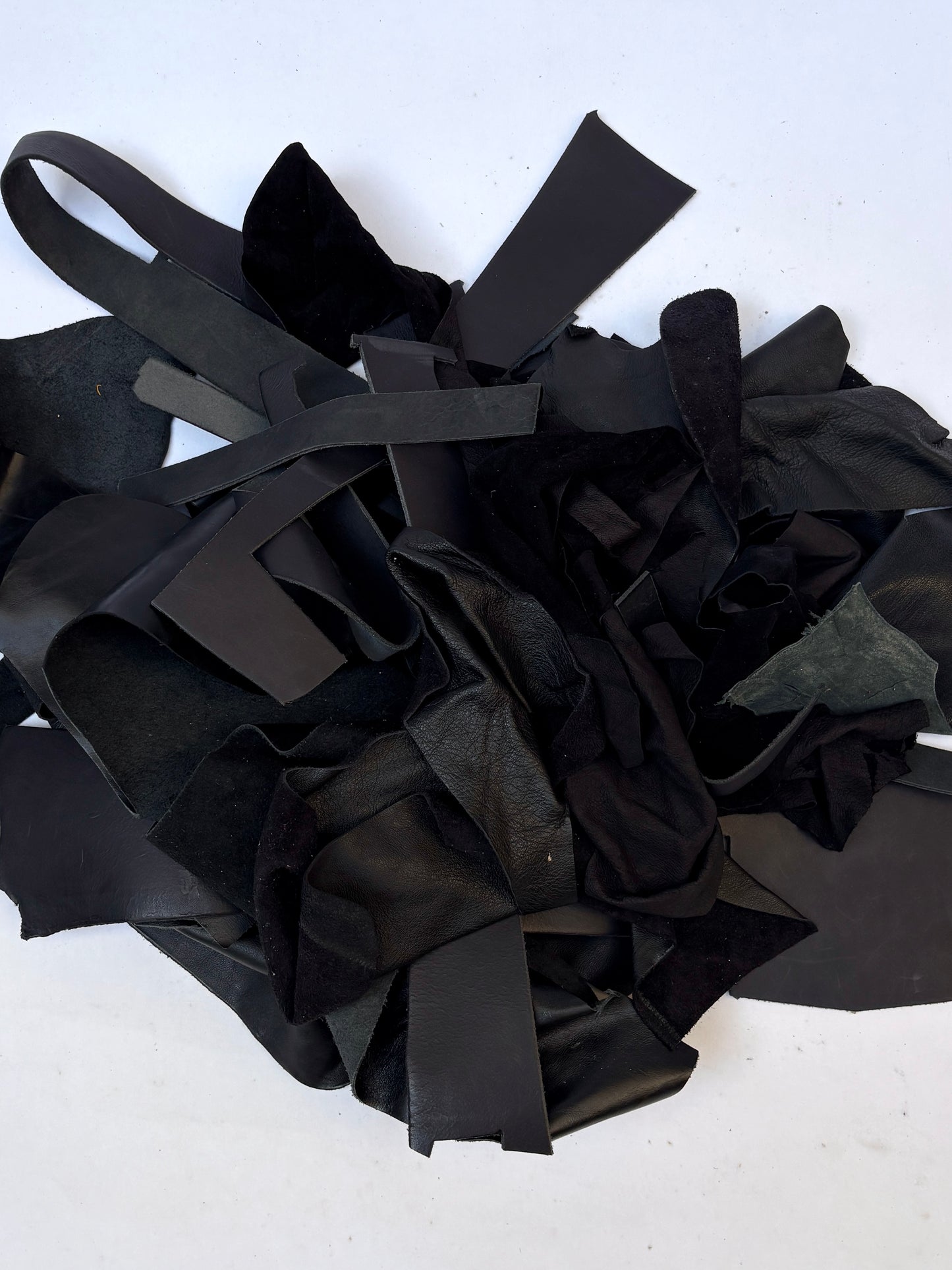 Pile of black leather offcuts with various textures