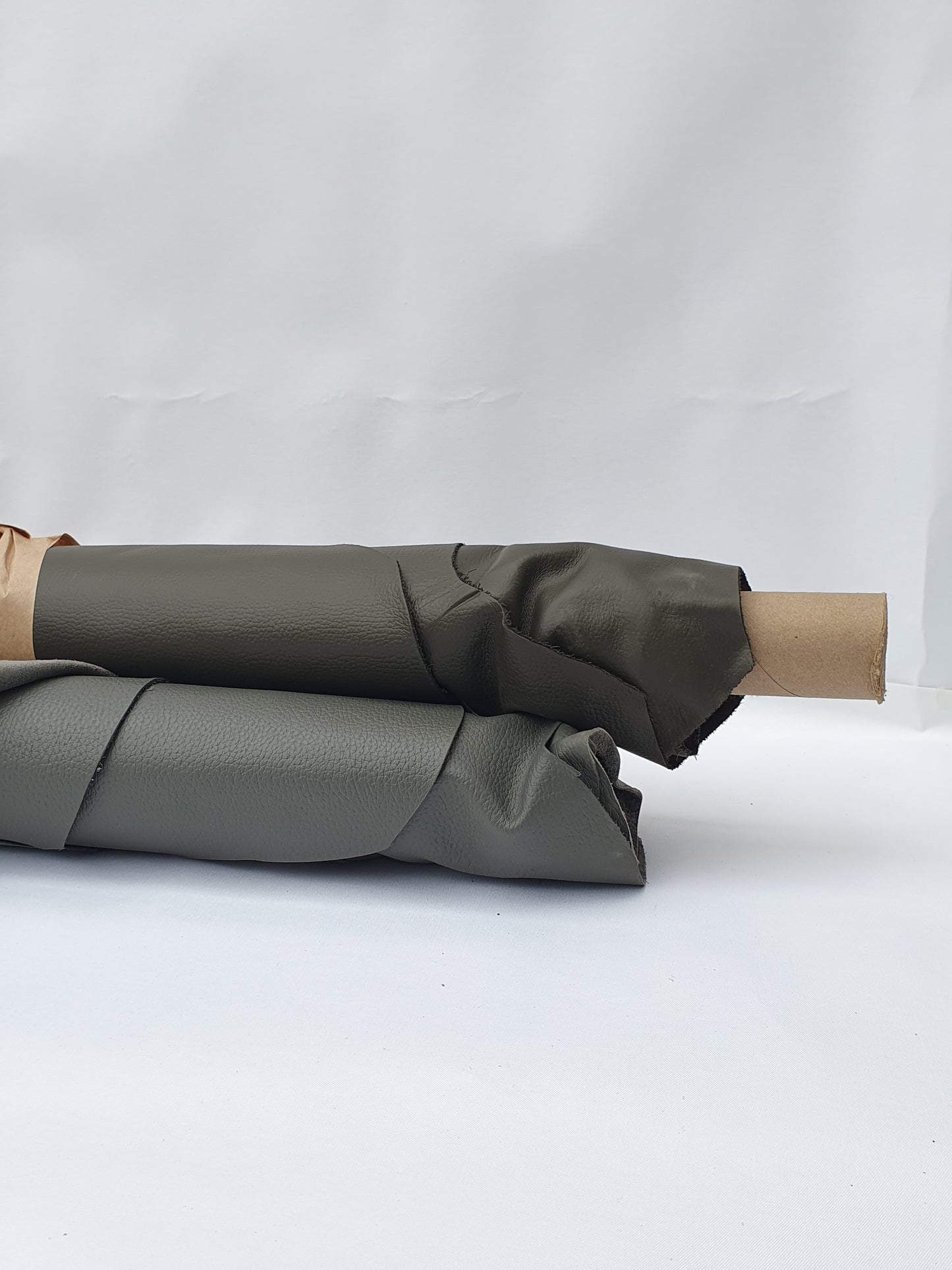 Rolled dark grey to brown leather showing a soft texture and folded edge