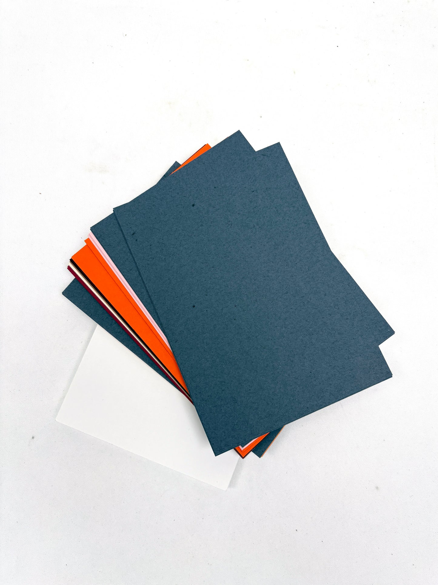 Stack of various coloured papers, texture visible