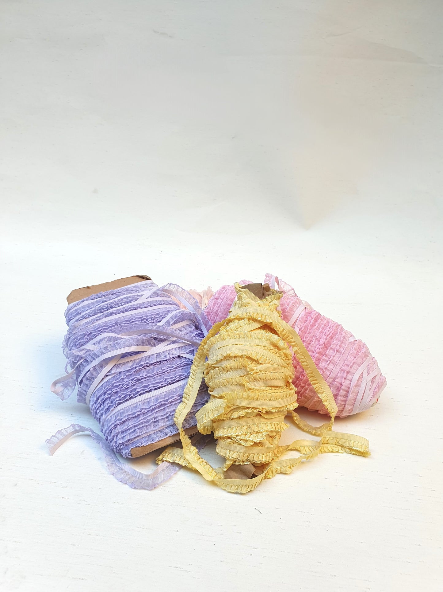 3 rolled up pastel-coloured piping trim laces