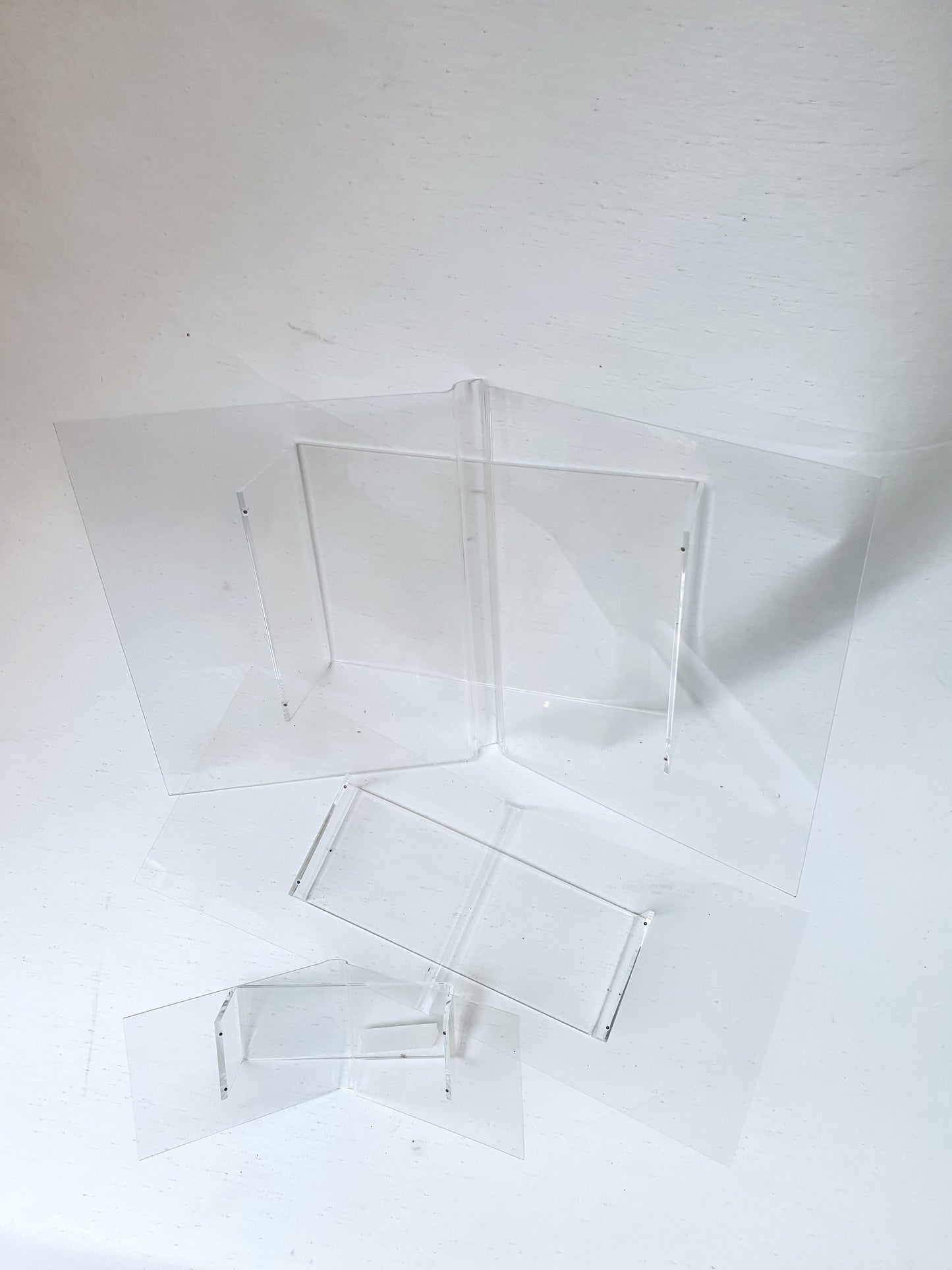 3 different sizes of clear plastic perspex book cradles