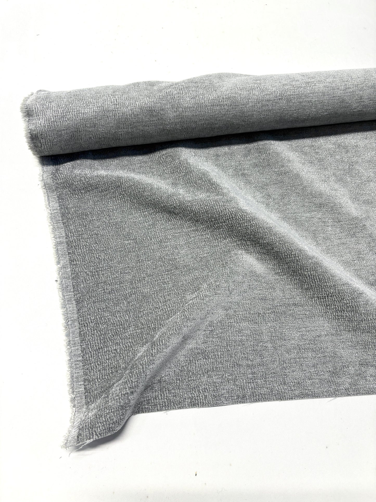 Close-up of rolled grey textured weave velvet fabric, partially unfolded