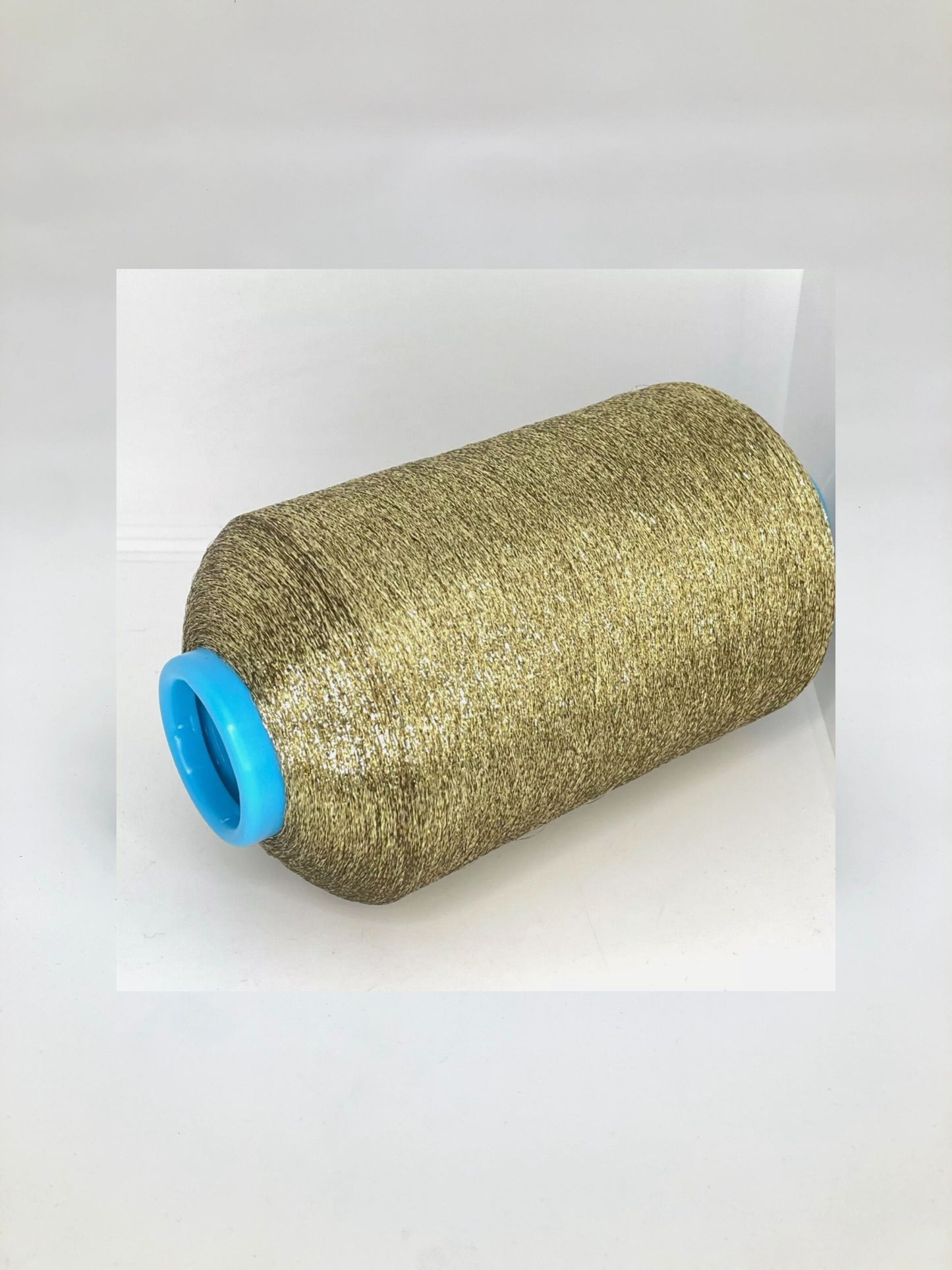 Roll of gold thread with a blue spool cap on a white background.