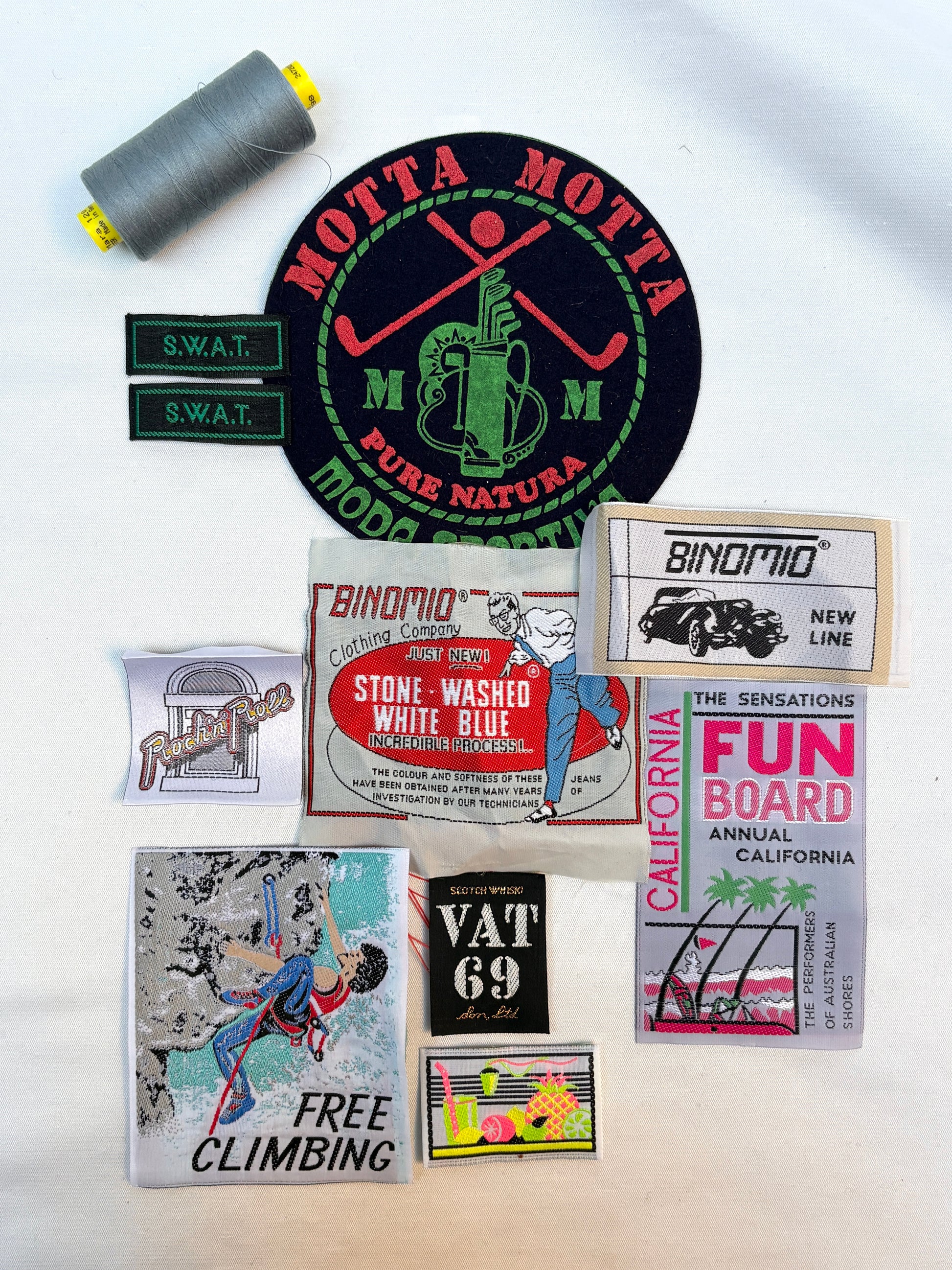 Collection of vintage-style product labels and a spool of thread on a white background