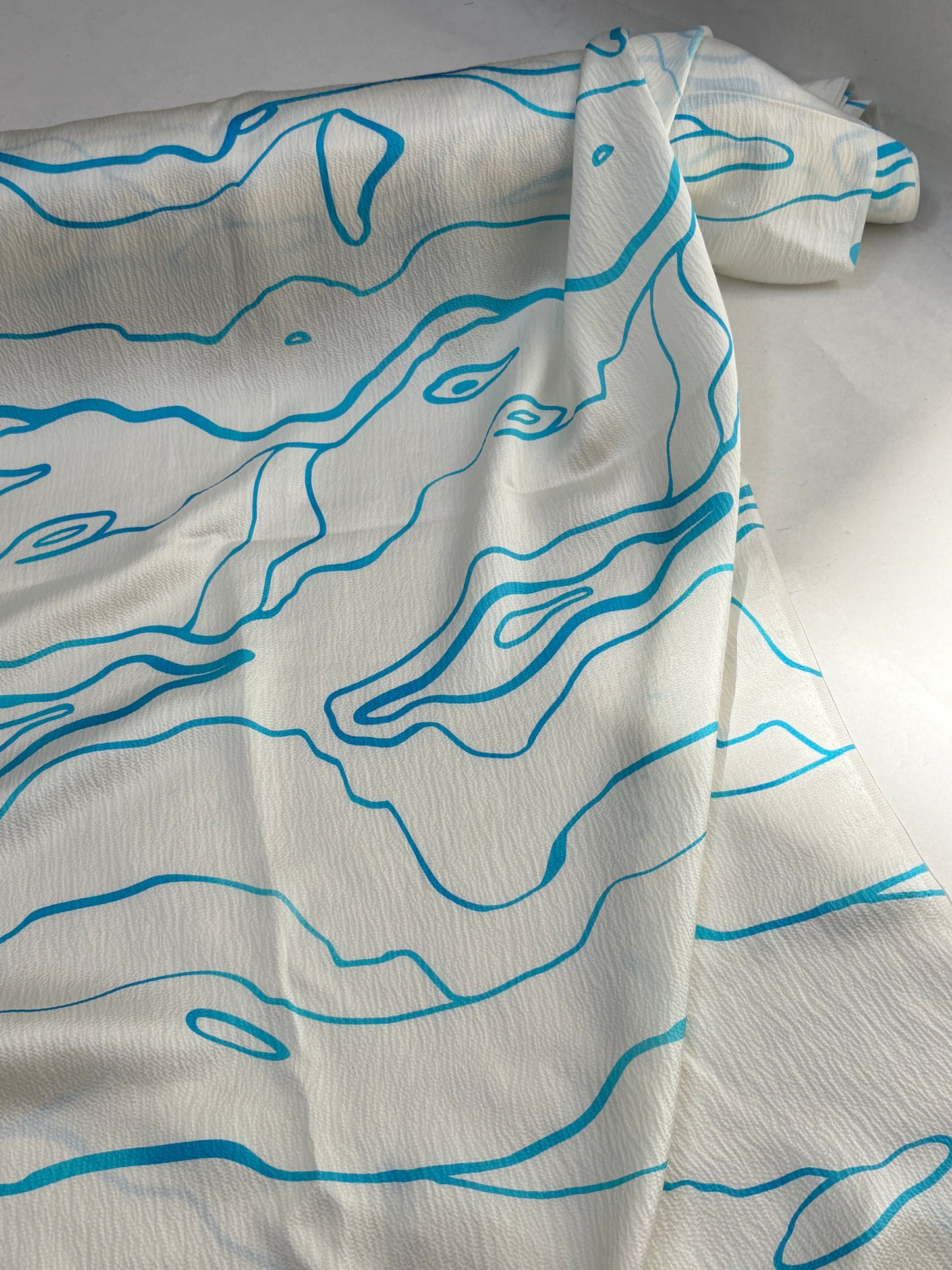 White fabric with blue abstract patterns on a white background