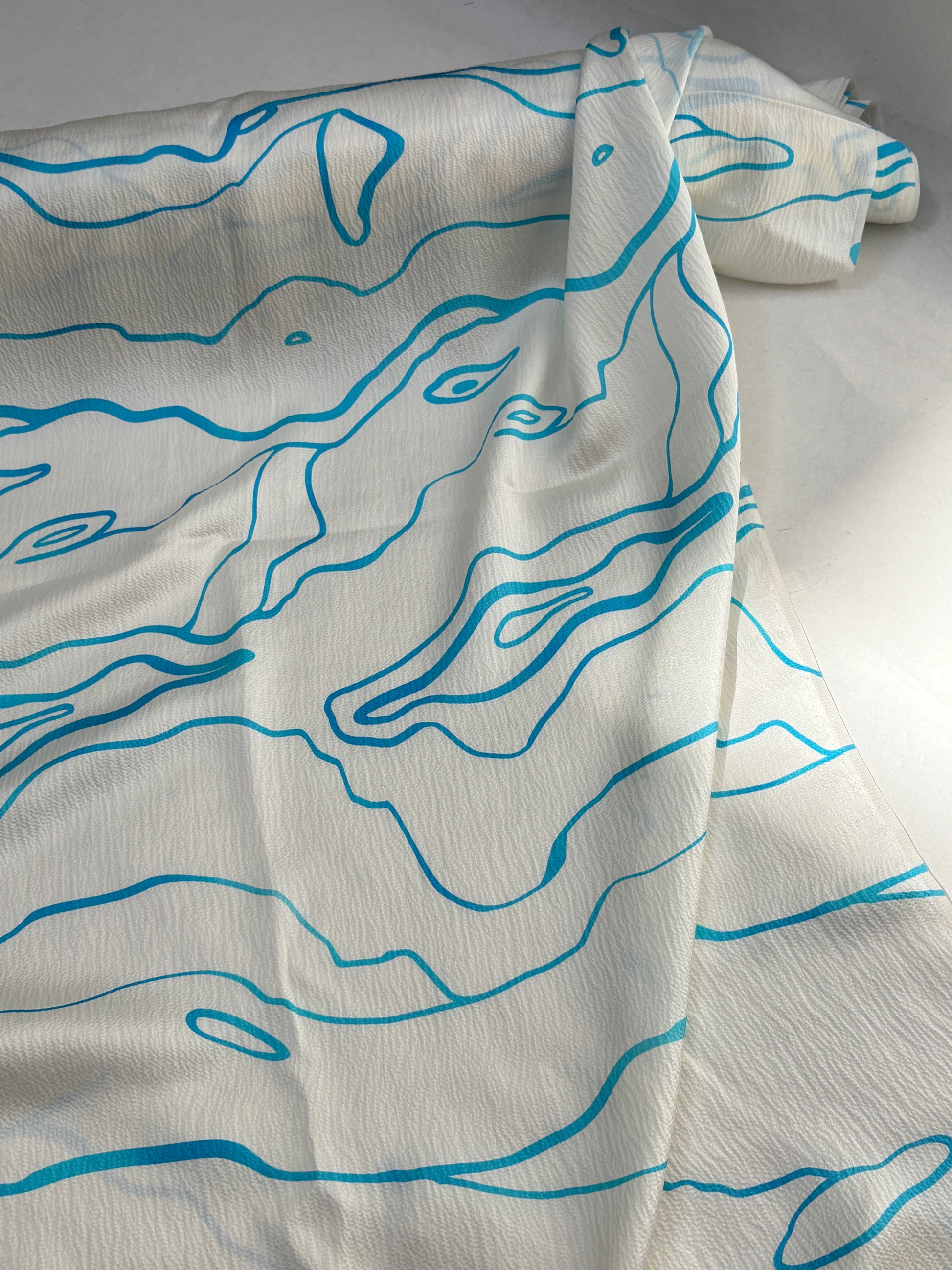 White fabric with blue abstract patterns on a white background