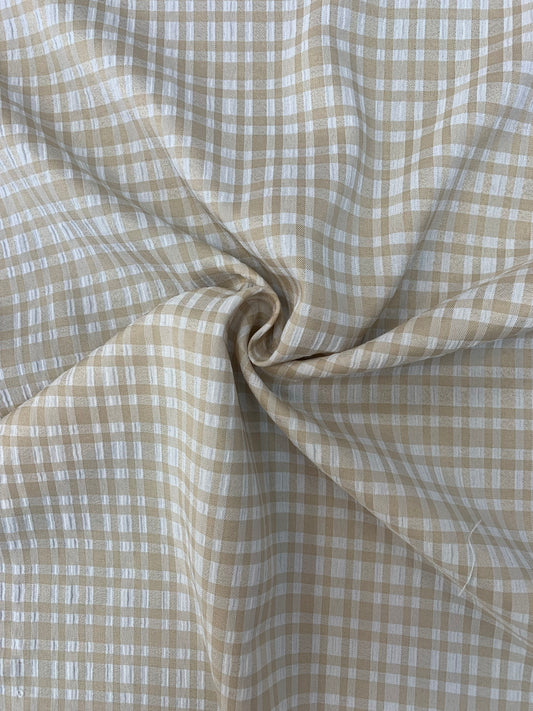 Textured close-up of apple check deadstock fabric in stone and white.