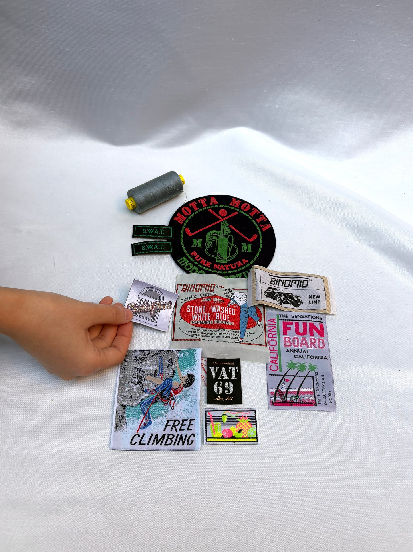 Collection of stickers on a white surface with a hand reaching towards them