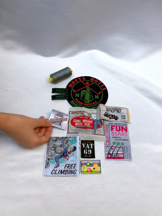 Collection of stickers on a white surface with a hand reaching towards them