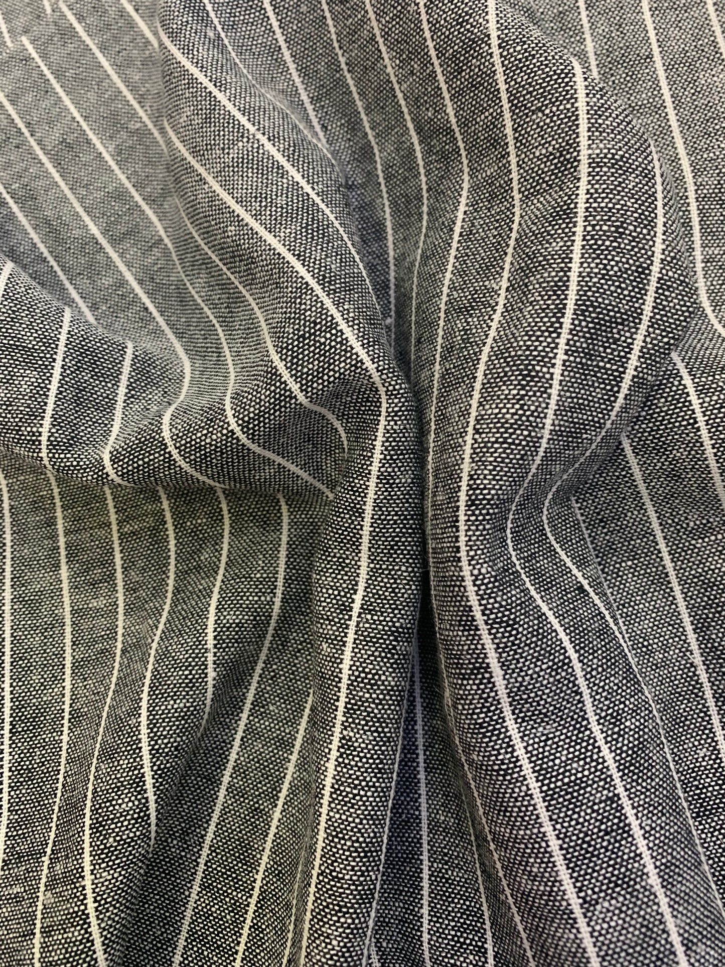 Folded detail of black-white stripe linen blend deadstock fabric.