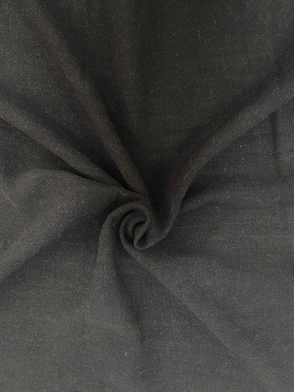 Black fabric gathered to show its soft surface and drape.