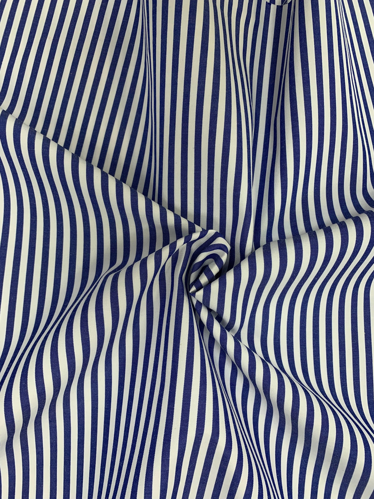 Close-up of denim blue-white stripe fabric gathered in gentle folds.