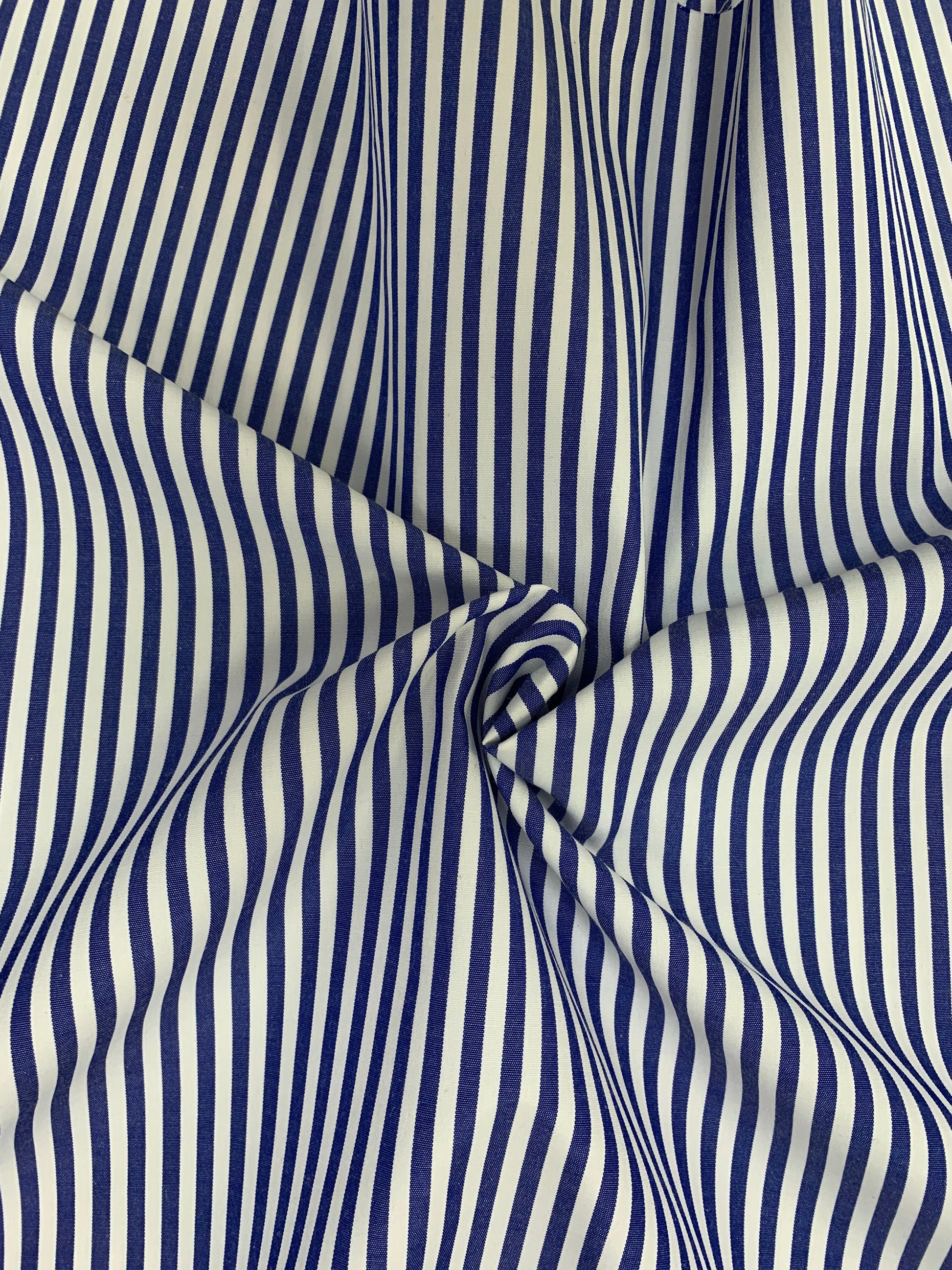 Close-up of denim blue-white stripe fabric gathered in gentle folds.
