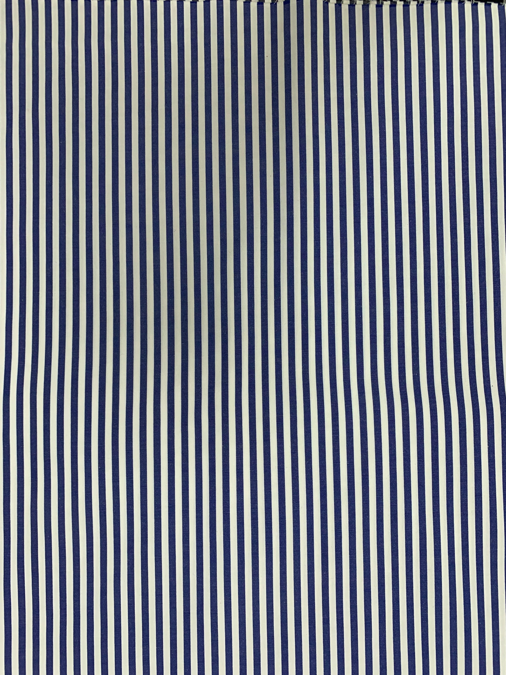 Denim blue-white stripe fabric laid flat in close detail.