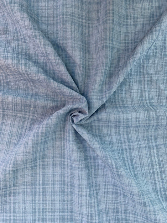Close detail of denim check fabric gathered in gentle folds.