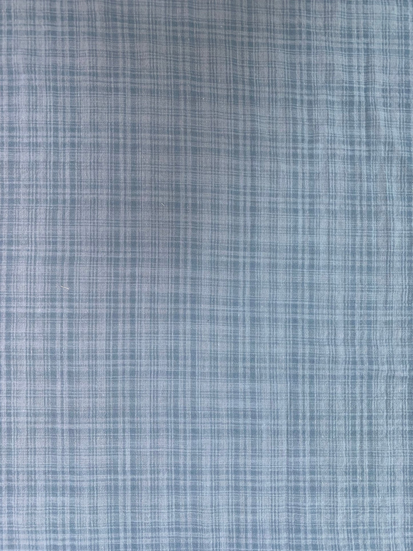 Textile detail showing the denim-toned check pattern.
