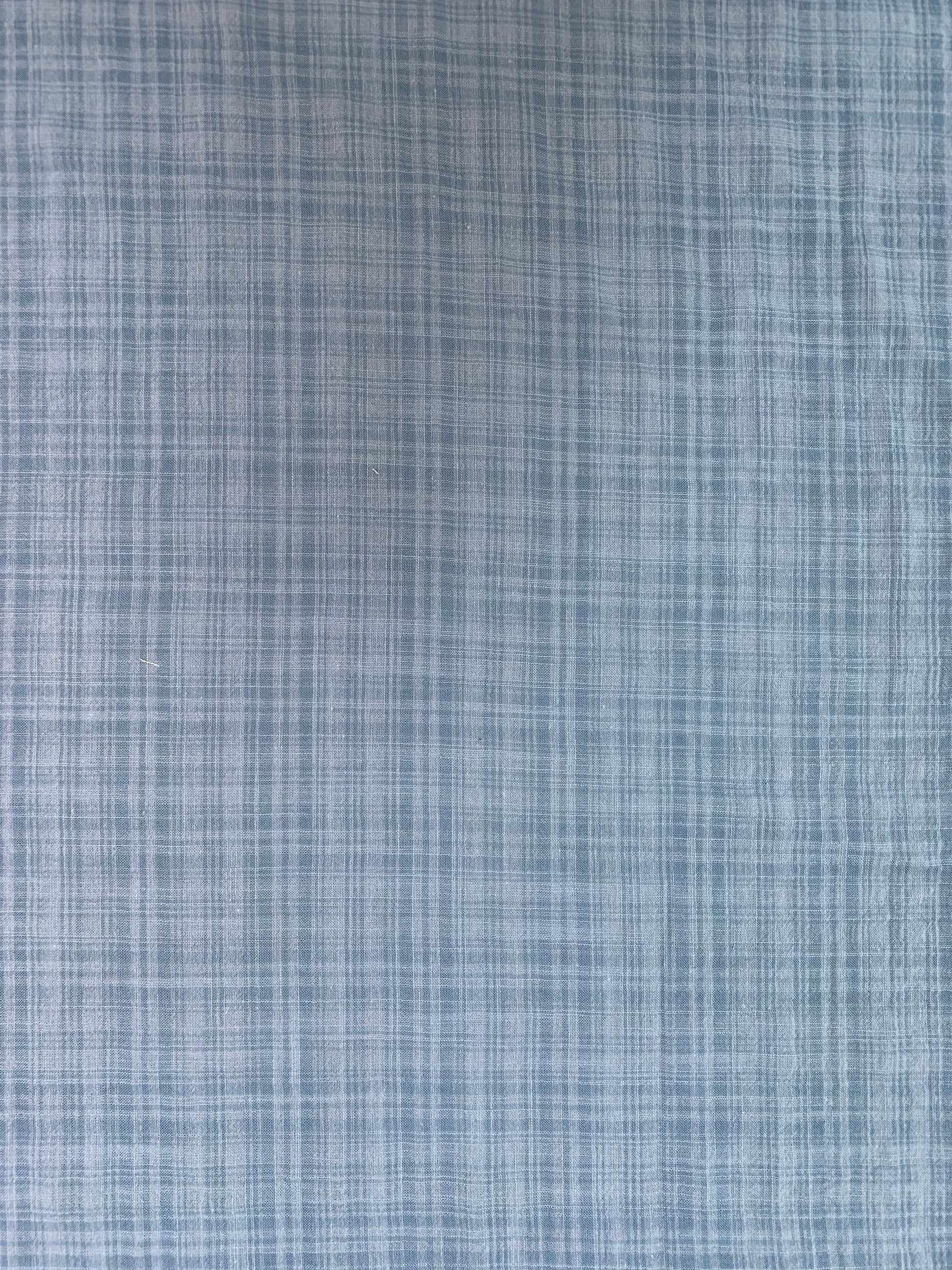 Textile detail showing the denim-toned check pattern.