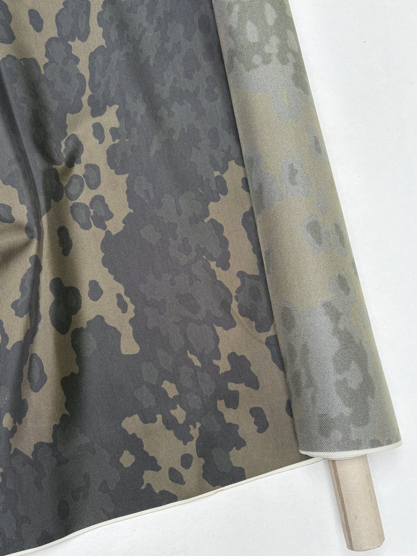 Dark green and khaki camouflage fabric shown in folded layers.