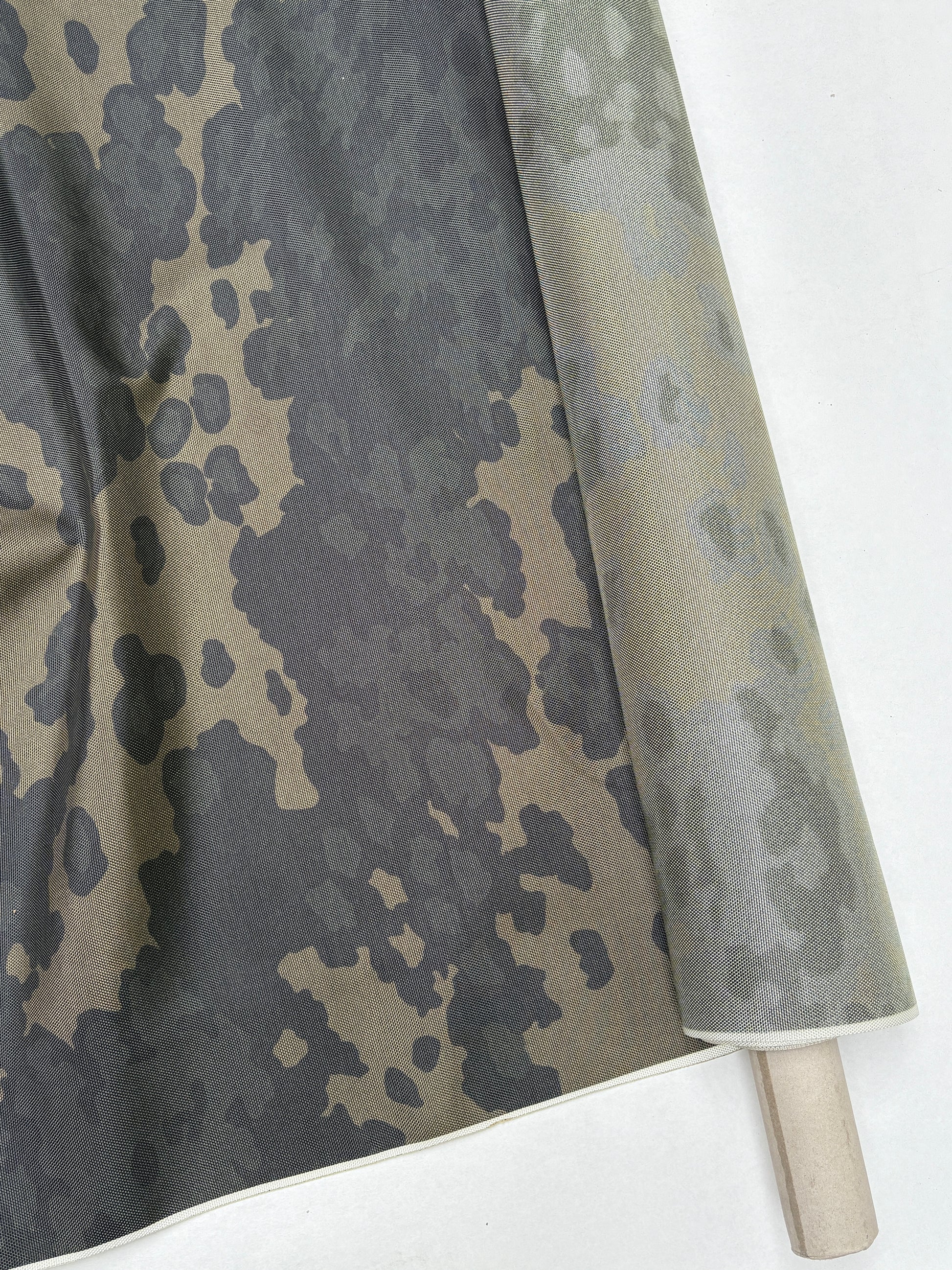 Dark green and khaki camouflage fabric shown in folded layers.