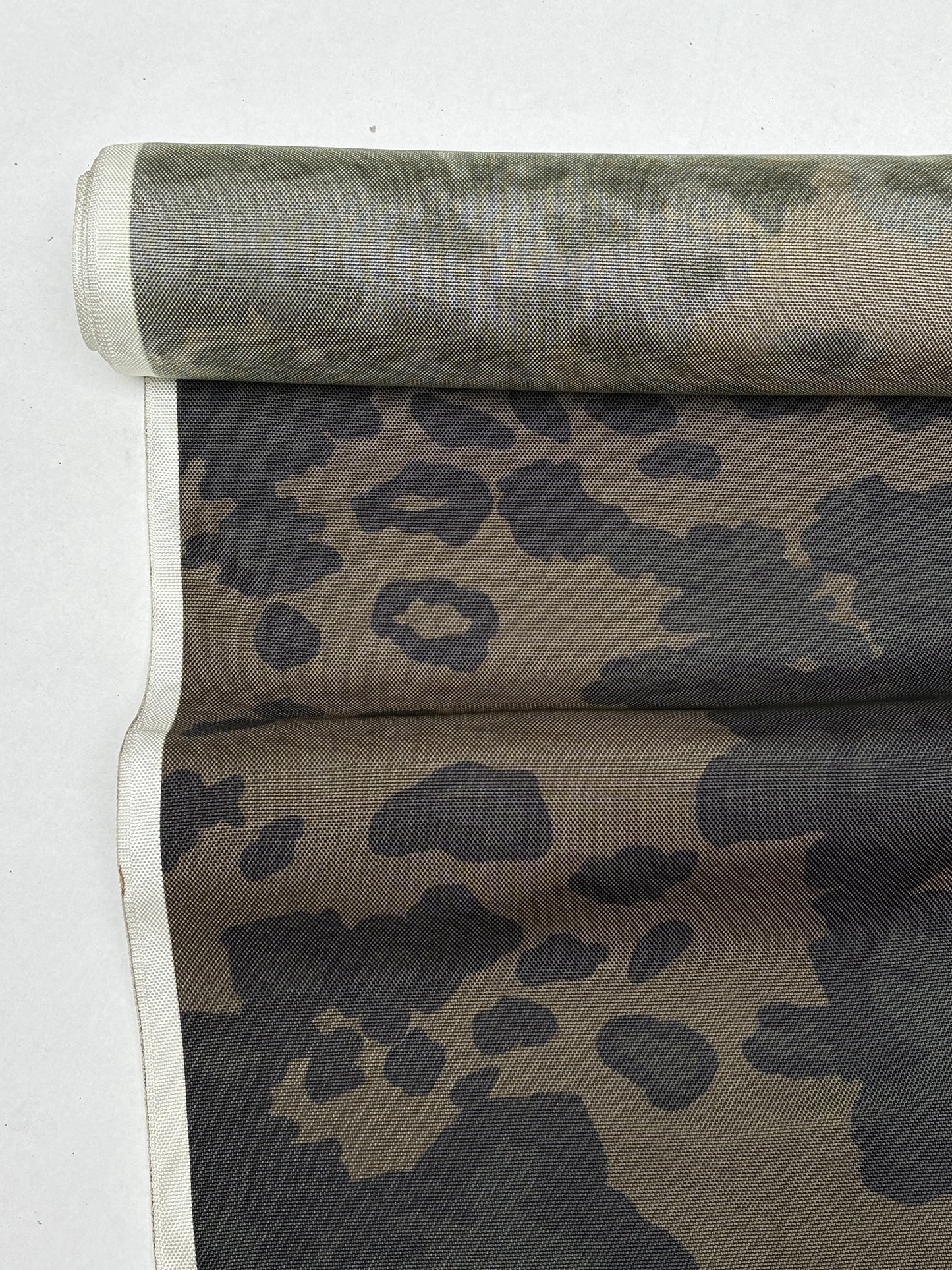 Folded camouflage fabric in dark green and khaki tones.