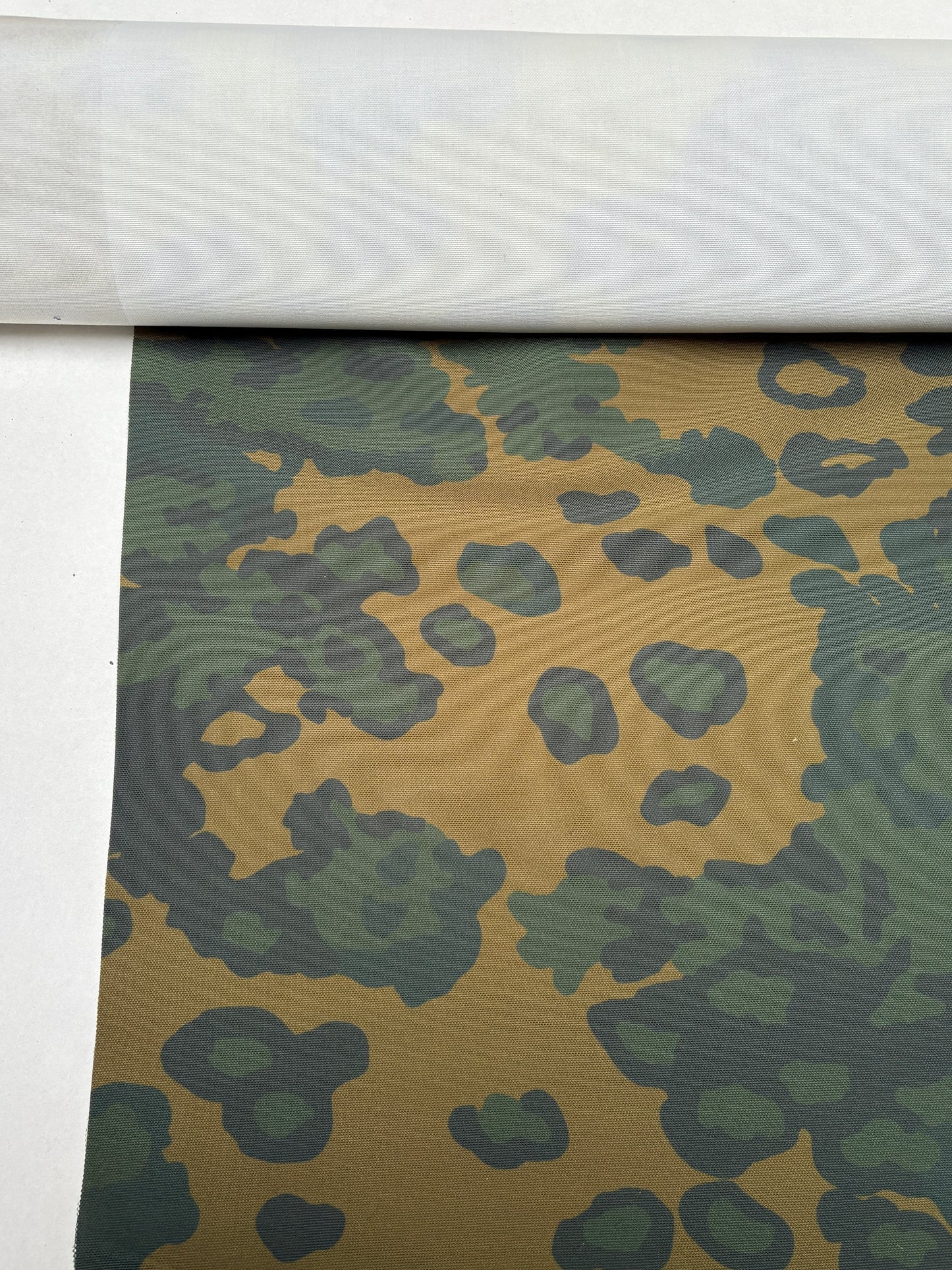 Pattern and texture visible on green-brown camouflage fabric.
