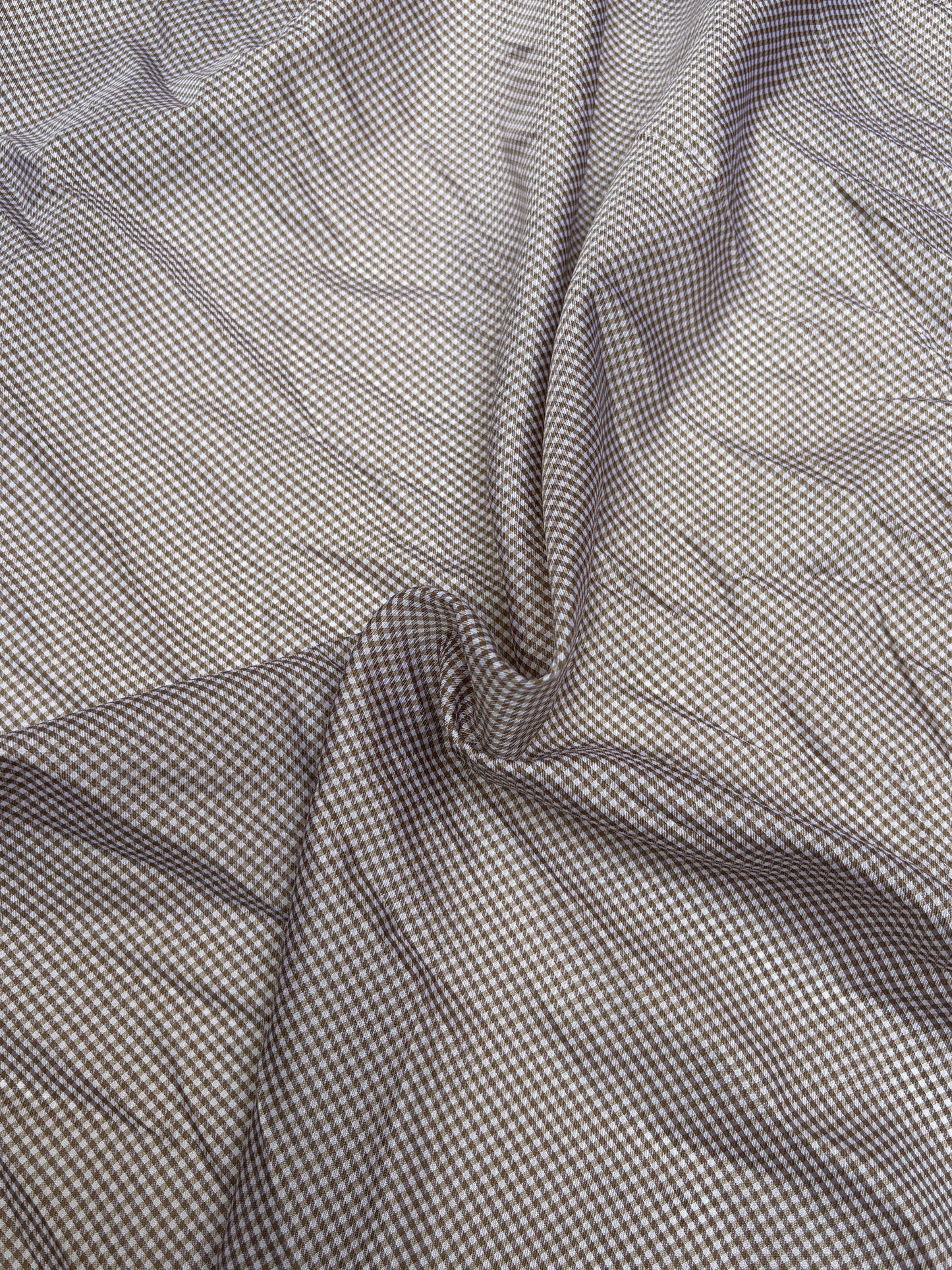 Lightweight checked fabric is draped with visible folds and creases
