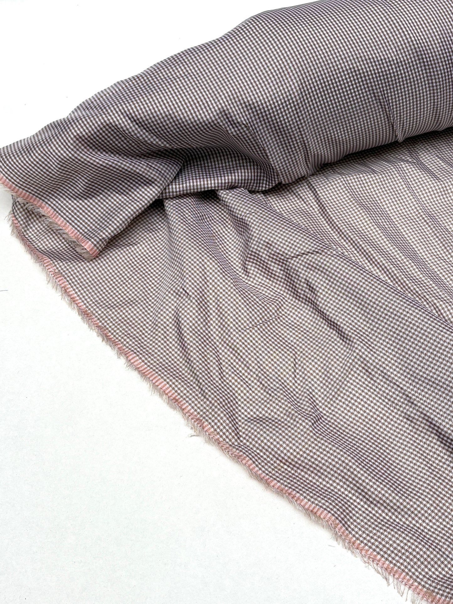 Rolled check fabric is displayed with soft wrinkles on white