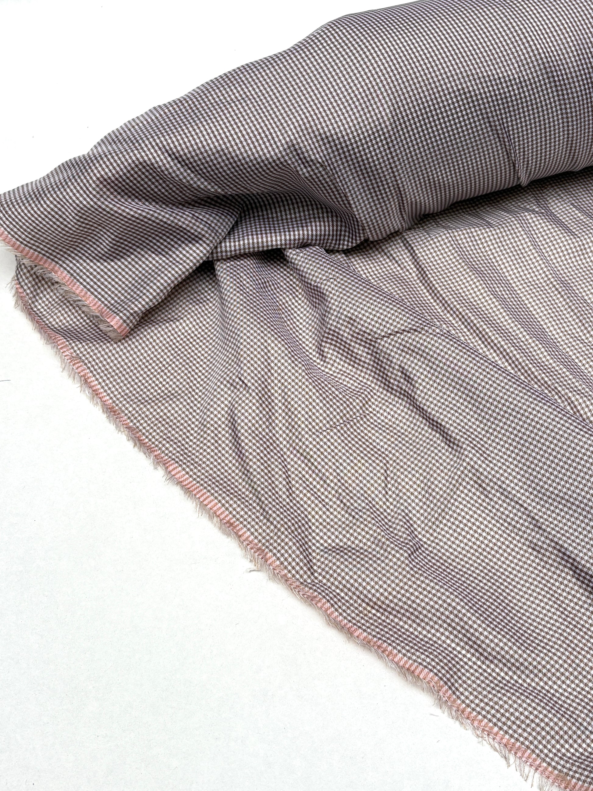 Rolled check fabric is displayed with soft wrinkles on white