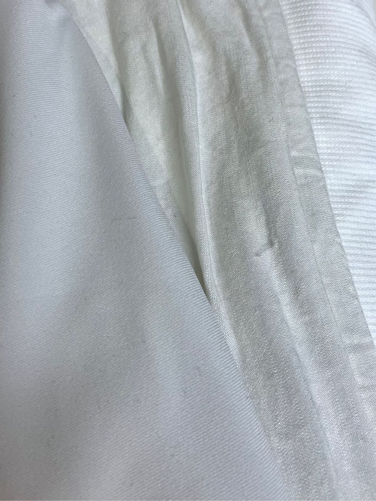 Close-up of white jersey fabric with various textures