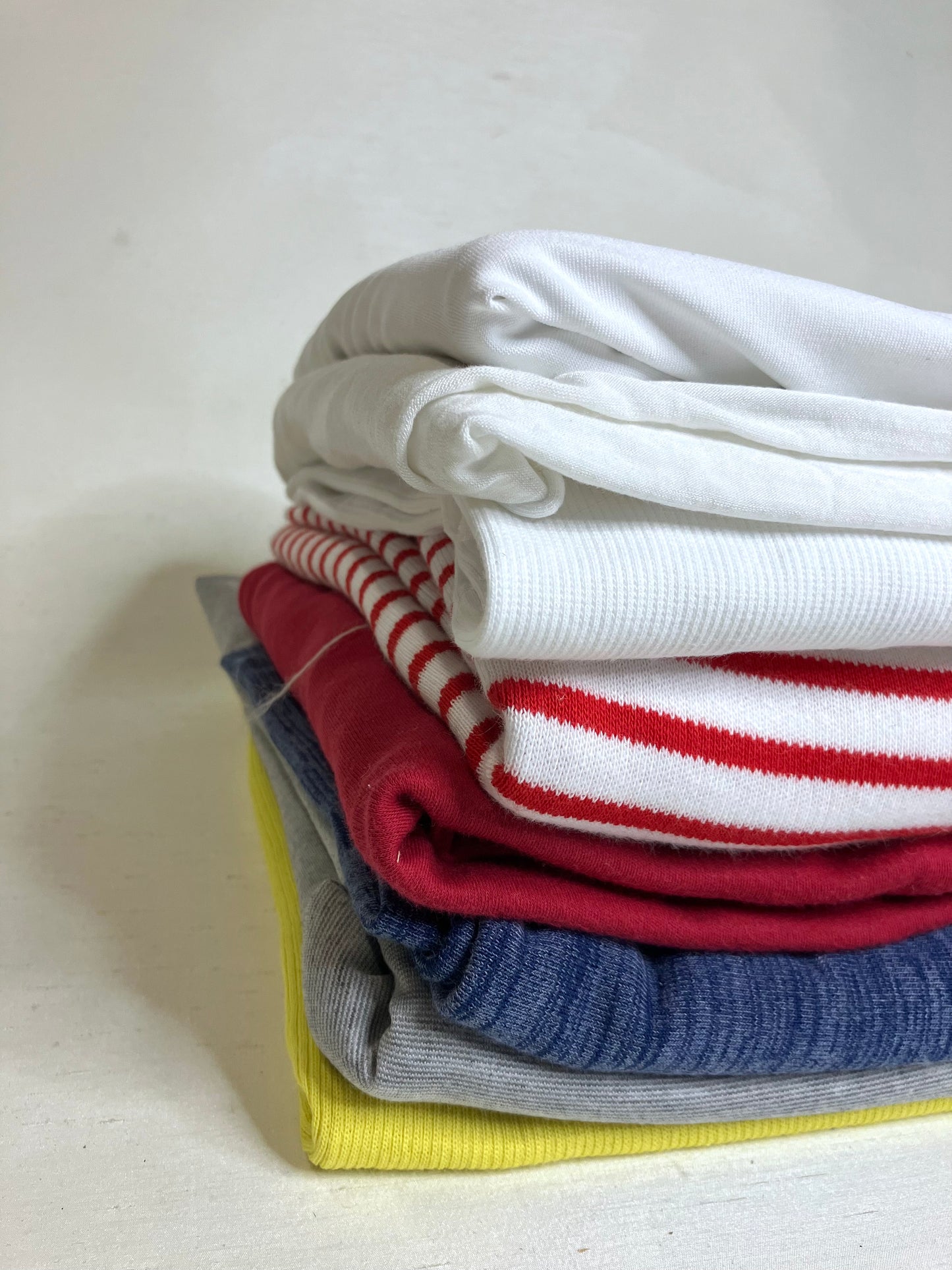 Pile of colourful jersey fabric with various textures