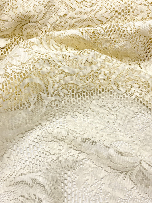 Close-up of beige lace fabric with intricate patterns