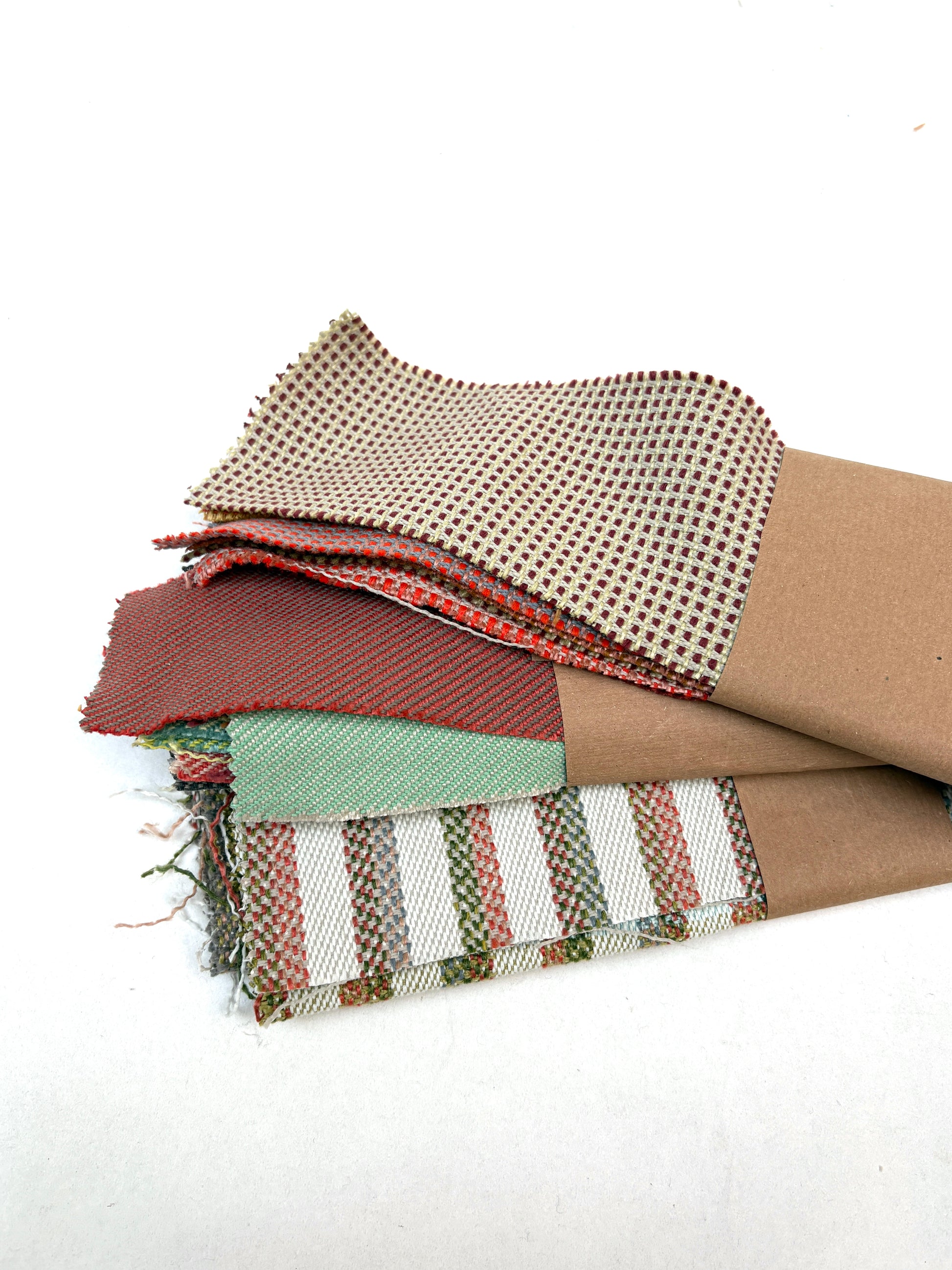 Mixed fabric offcuts are stacked on a white background.