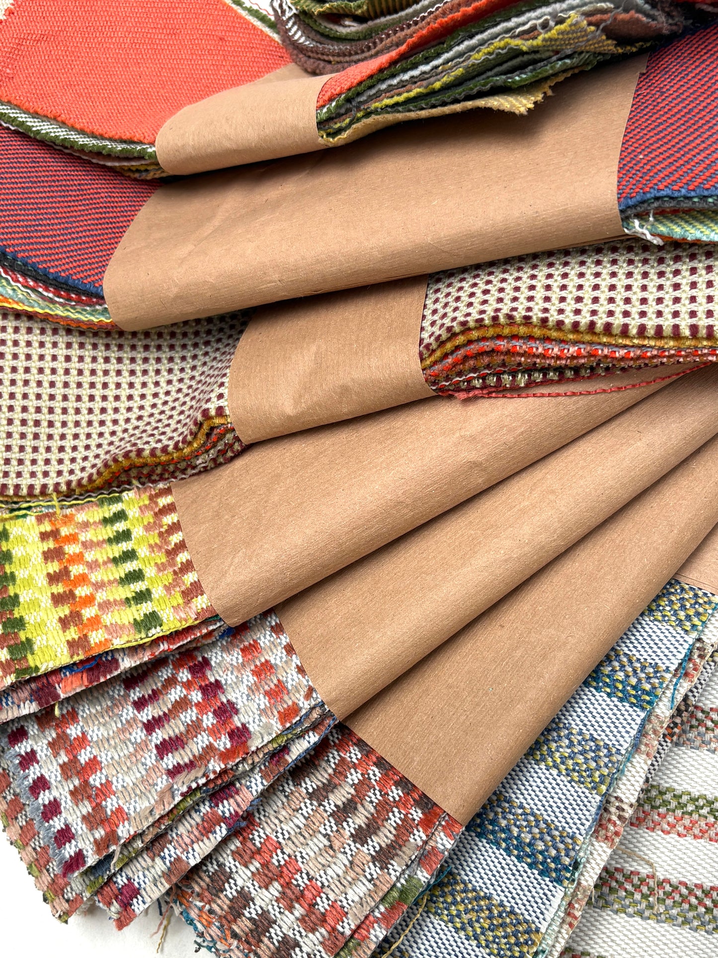 Stacked textile offcuts show mixed colours, patterns, and textures