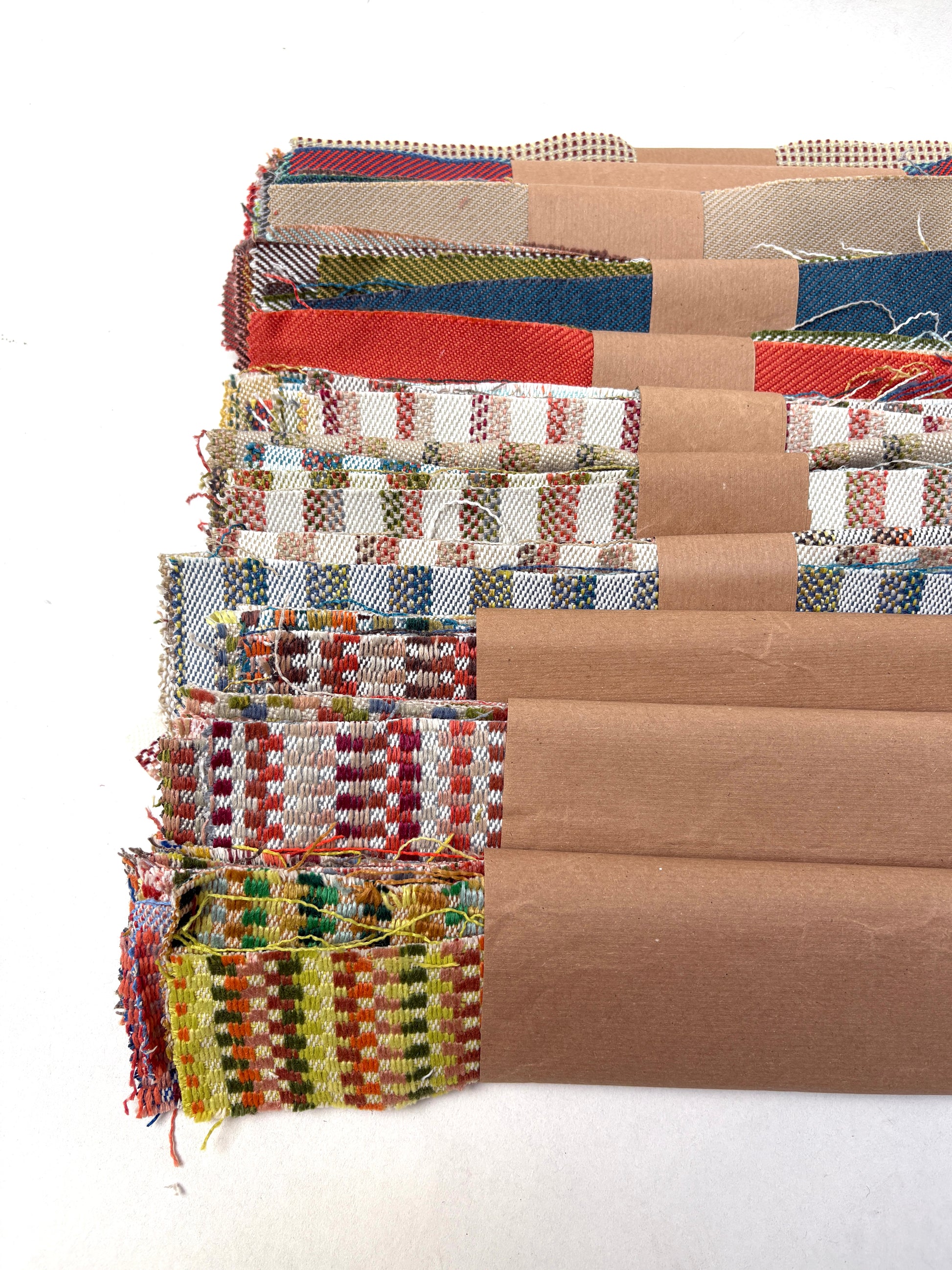 Patterned and plain fabric scraps are displayed on a white surface