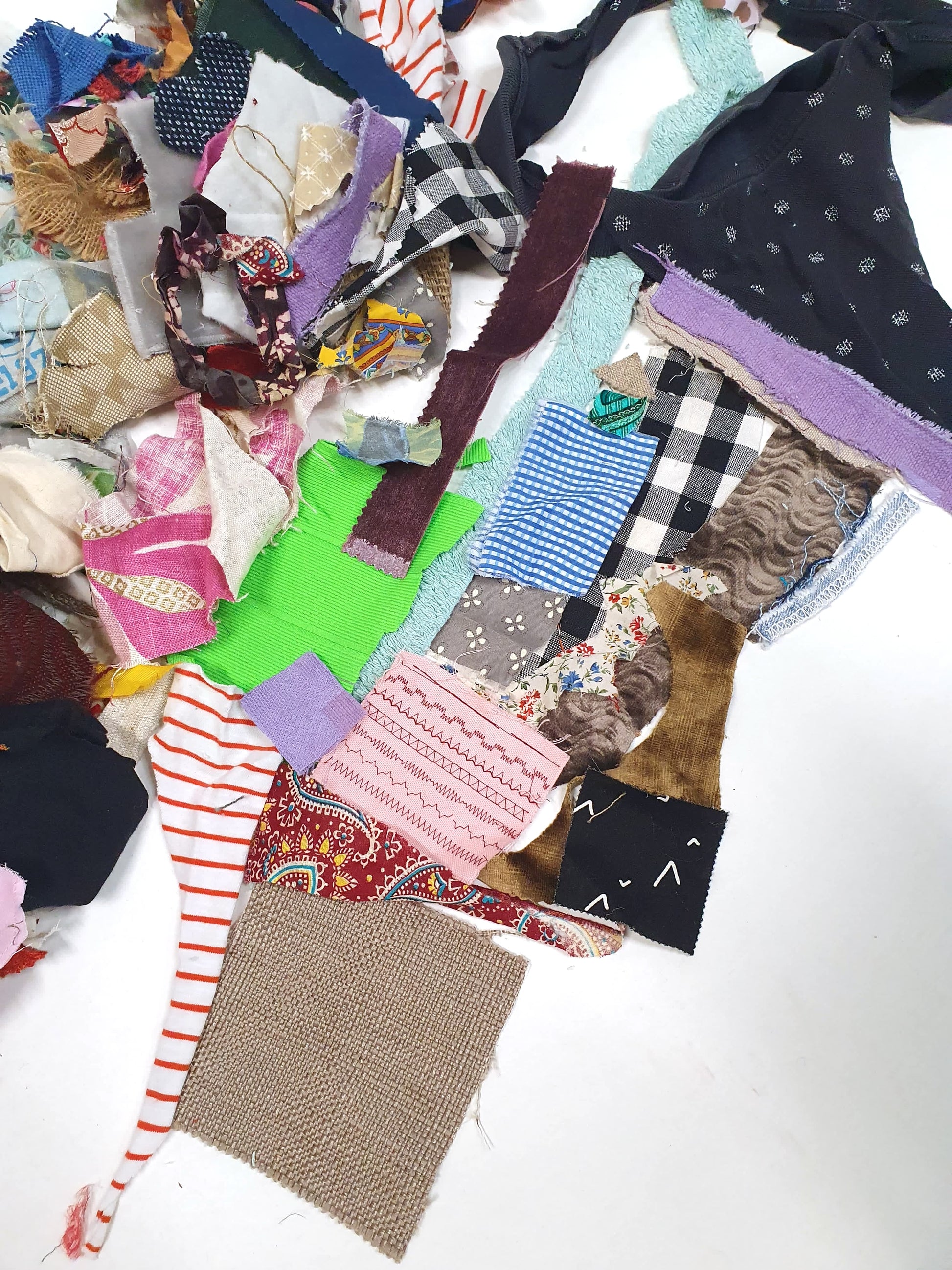 Close-up of mixed fabric offcuts in assorted colours, prints, patterns and textures.