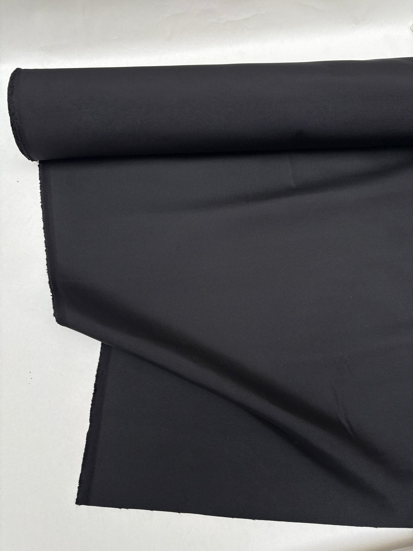 Black sailcloth-like fabric is displayed with soft folds