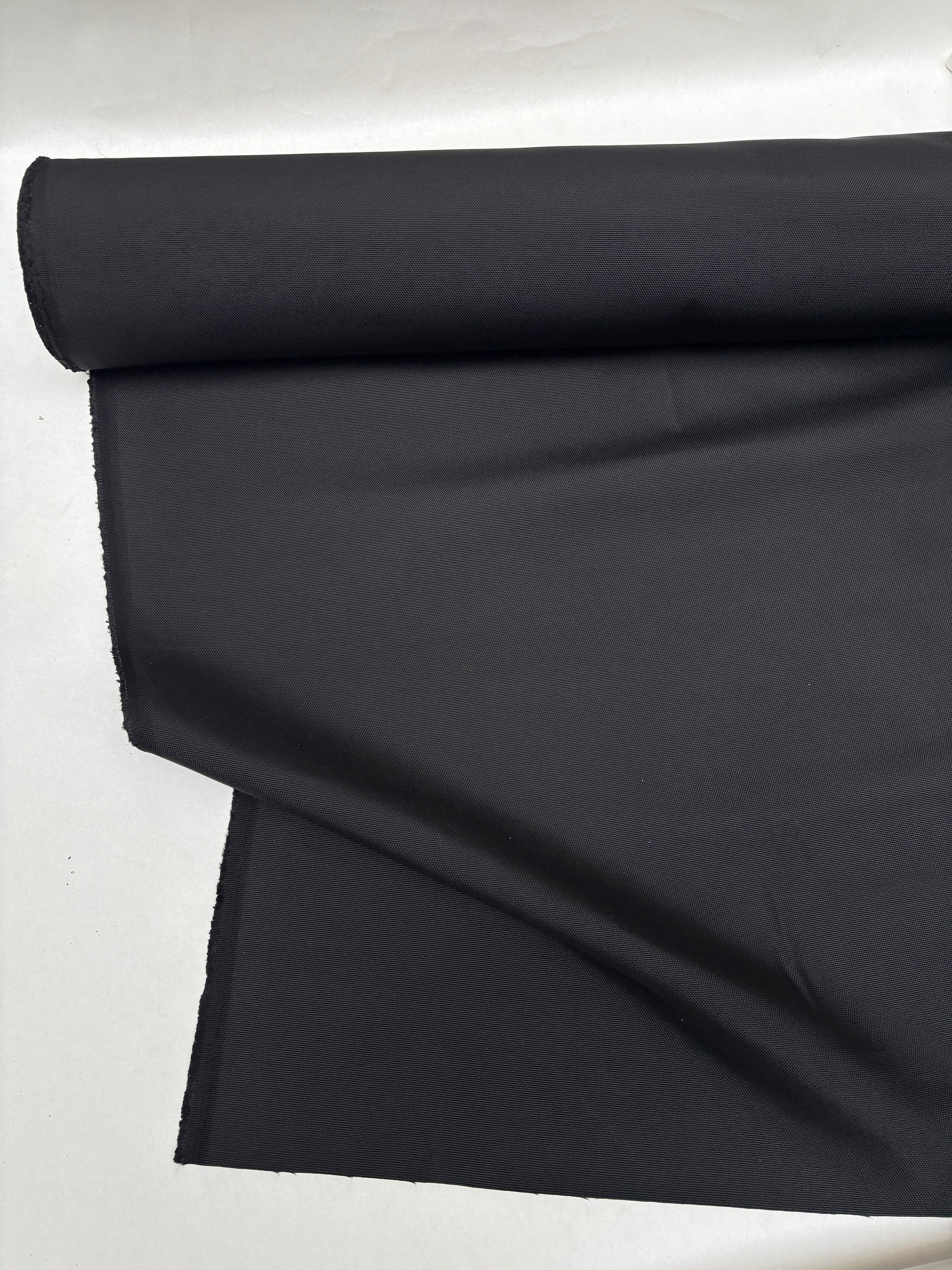 Black sailcloth-like fabric is displayed with soft folds
