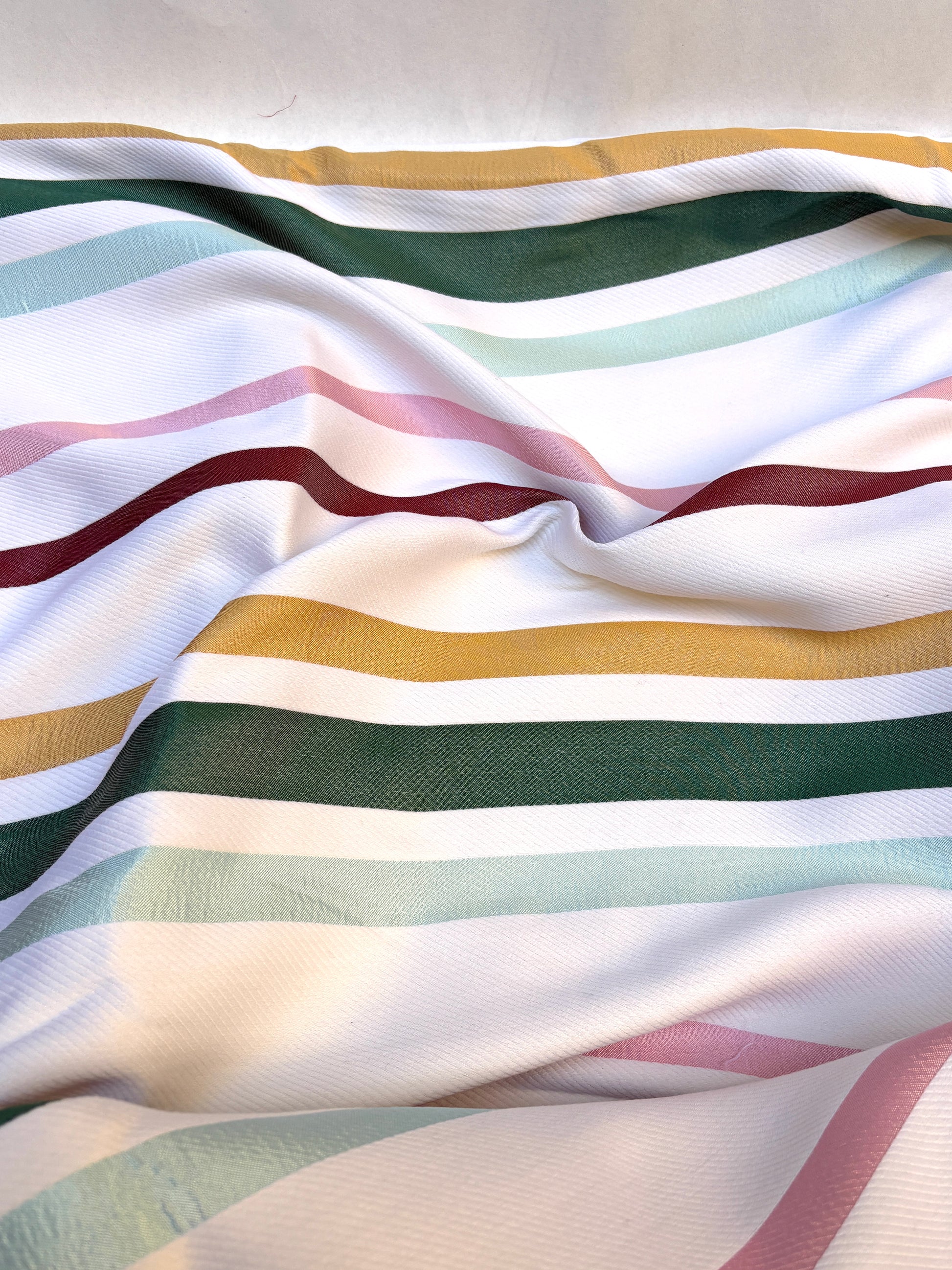     Folded striped fabric is gathered with visible soft creases.