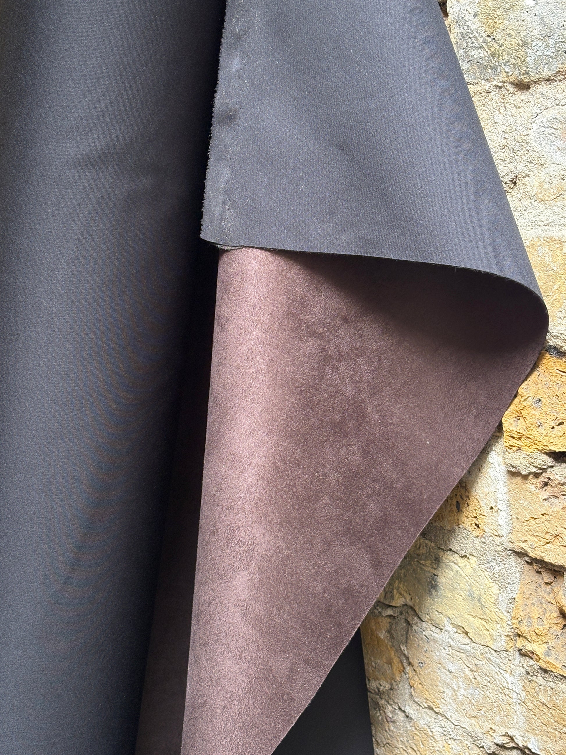 Suede-textured brown fabric is displayed with soft surface markings in detail
